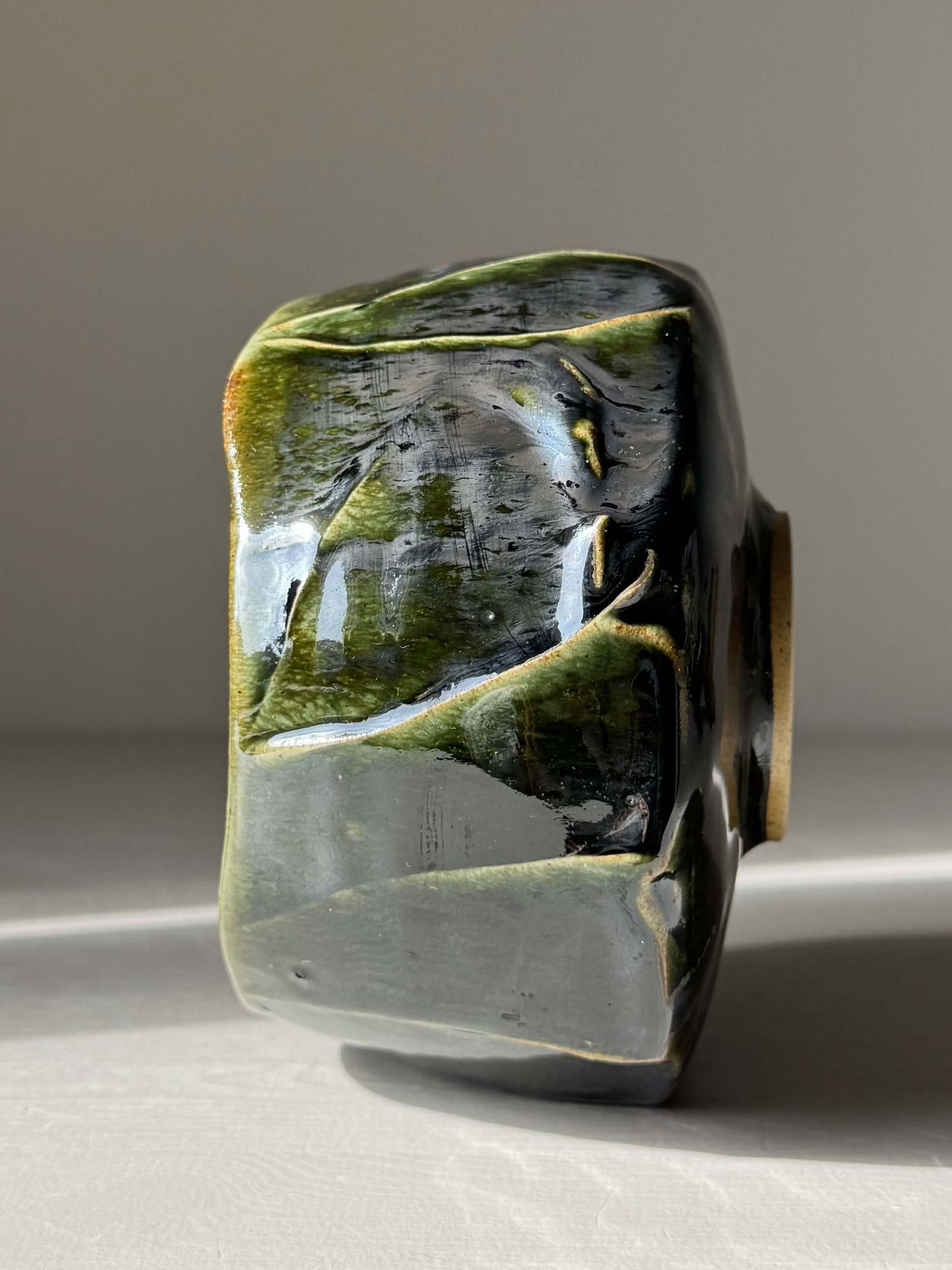 Side view of textured handmade ceramic bowl from Textured Matcha Bowl - Hinoki Series #06 with green hues and unique glaze finish.