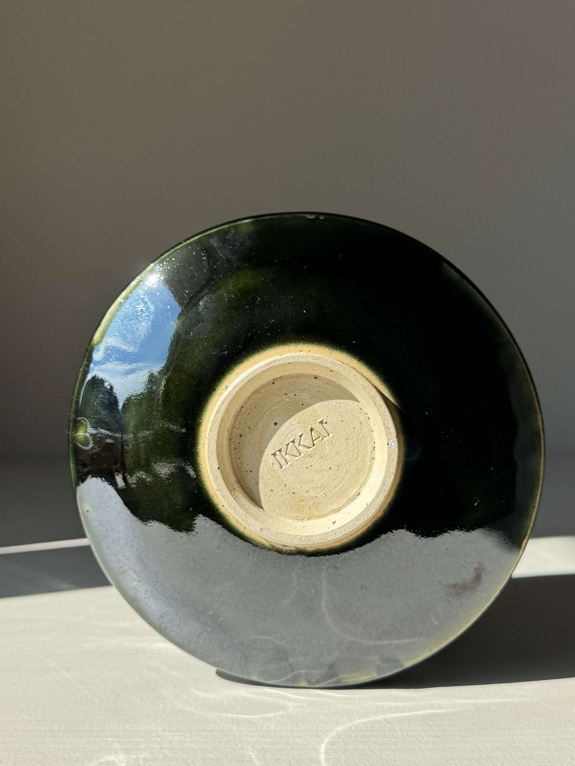 Bottom view of a handmade ceramic Textured Matcha Bowl - Hinoki Series #05 with green glaze and textured finish.