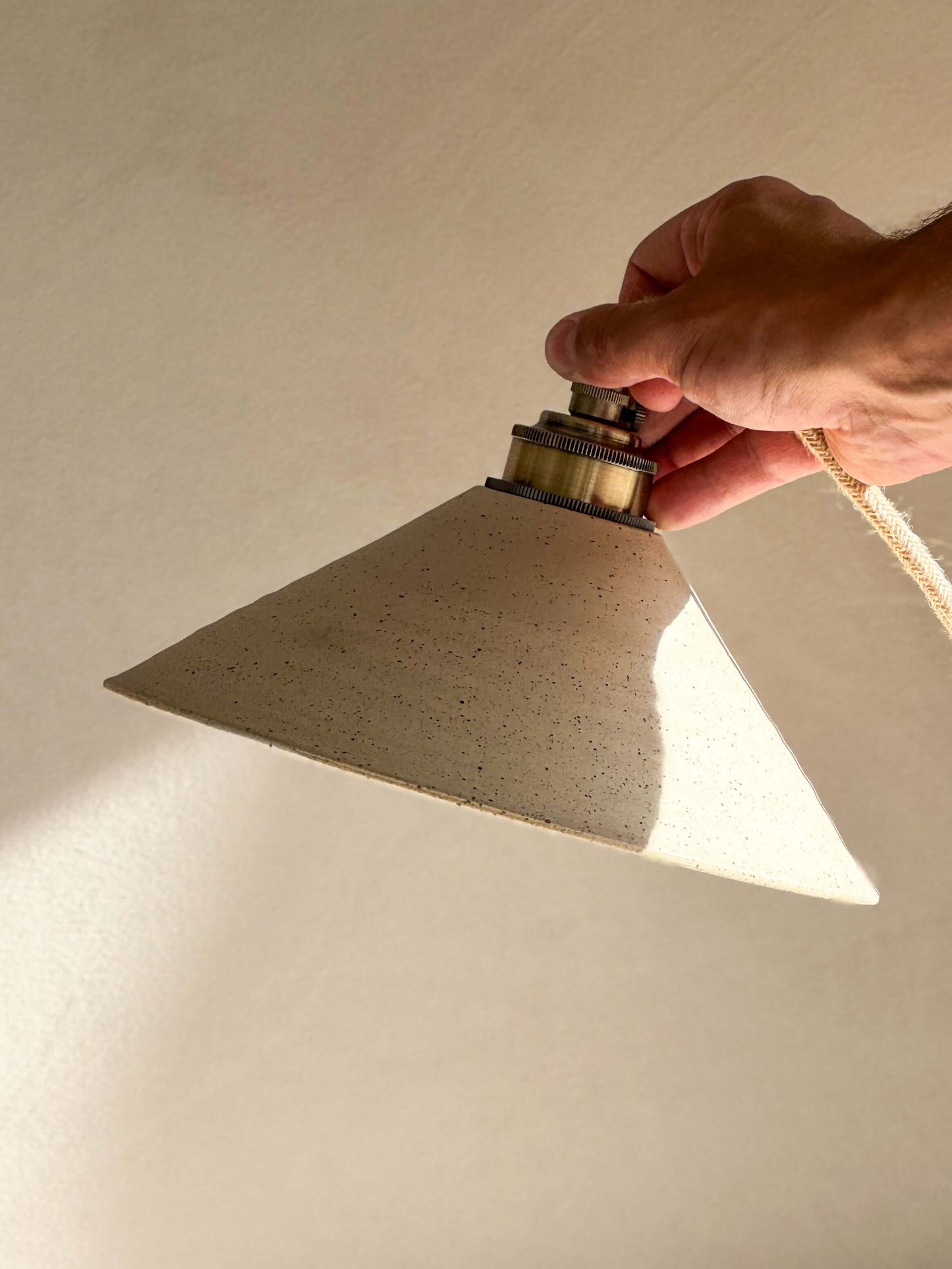 Hand holding Ceramic Lamp Shade – Half Glossy White Glaze, handmade ceramic with raw unglazed exterior and glossy interior.