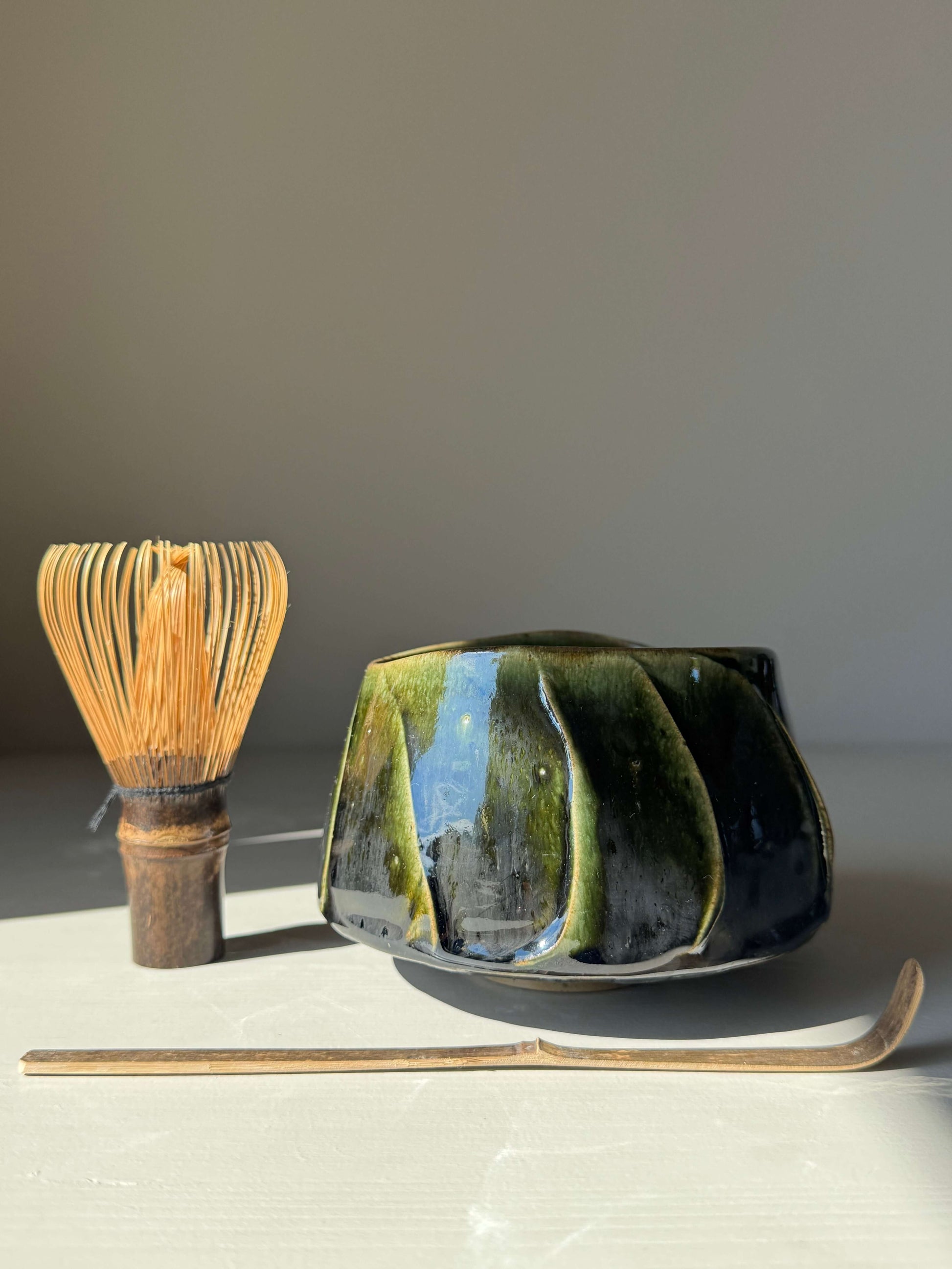 Textured Matcha Bowl - Hinoki Series #01 with handmade ceramic design, featuring a green glaze and textured finish next to a matcha whisk.