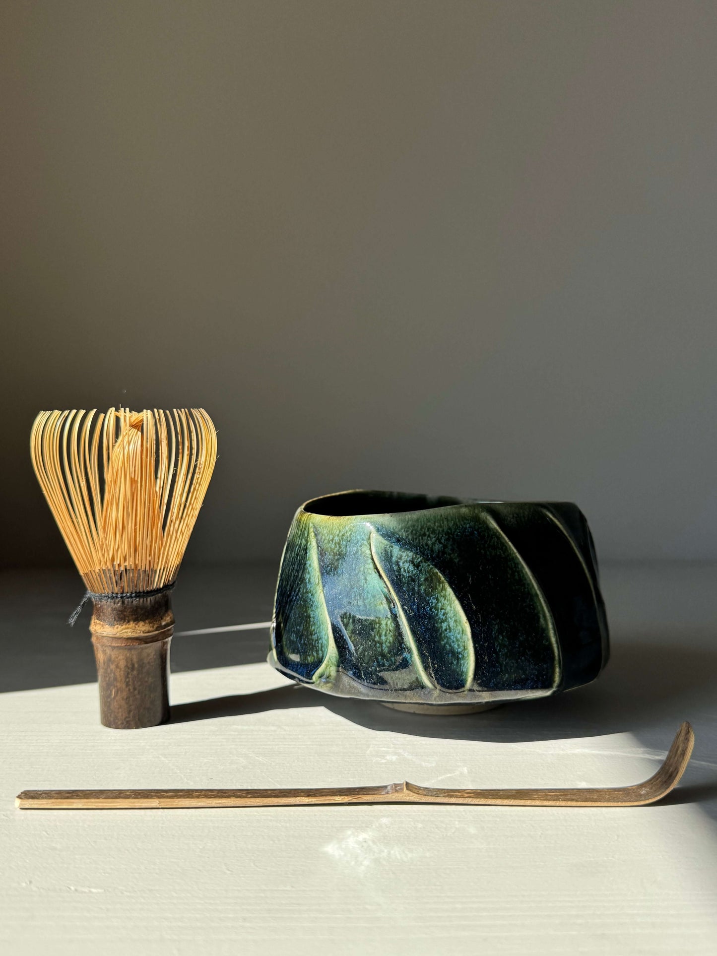 Textured Matcha Bowl - Hinoki Series #03 with green glaze, handmade ceramic, next to a bamboo whisk and scoop for tea rituals.