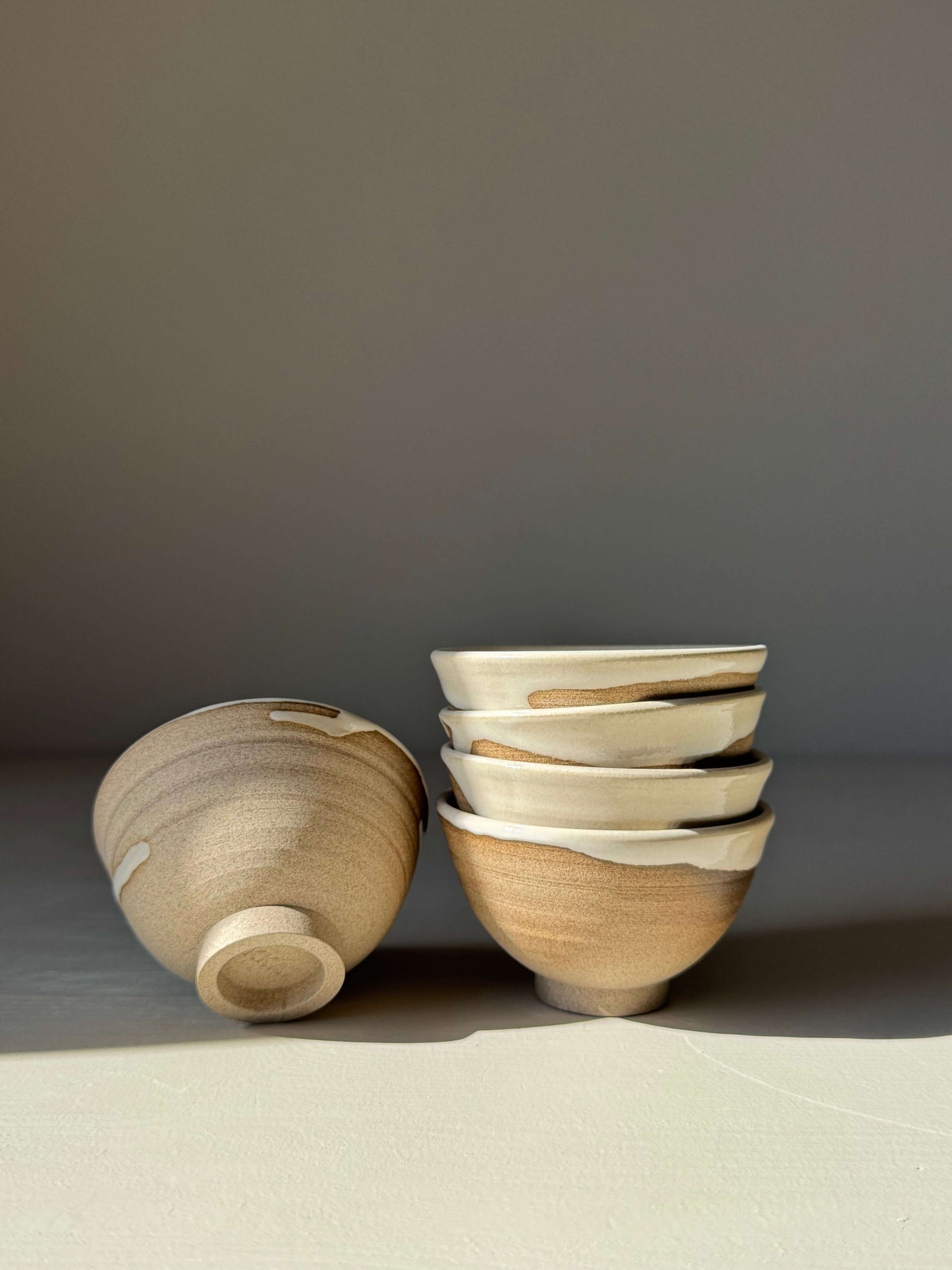 Stack of handmade ceramic Soya Bowl - Yuki Series, showing sandy clay and soft white glaze.