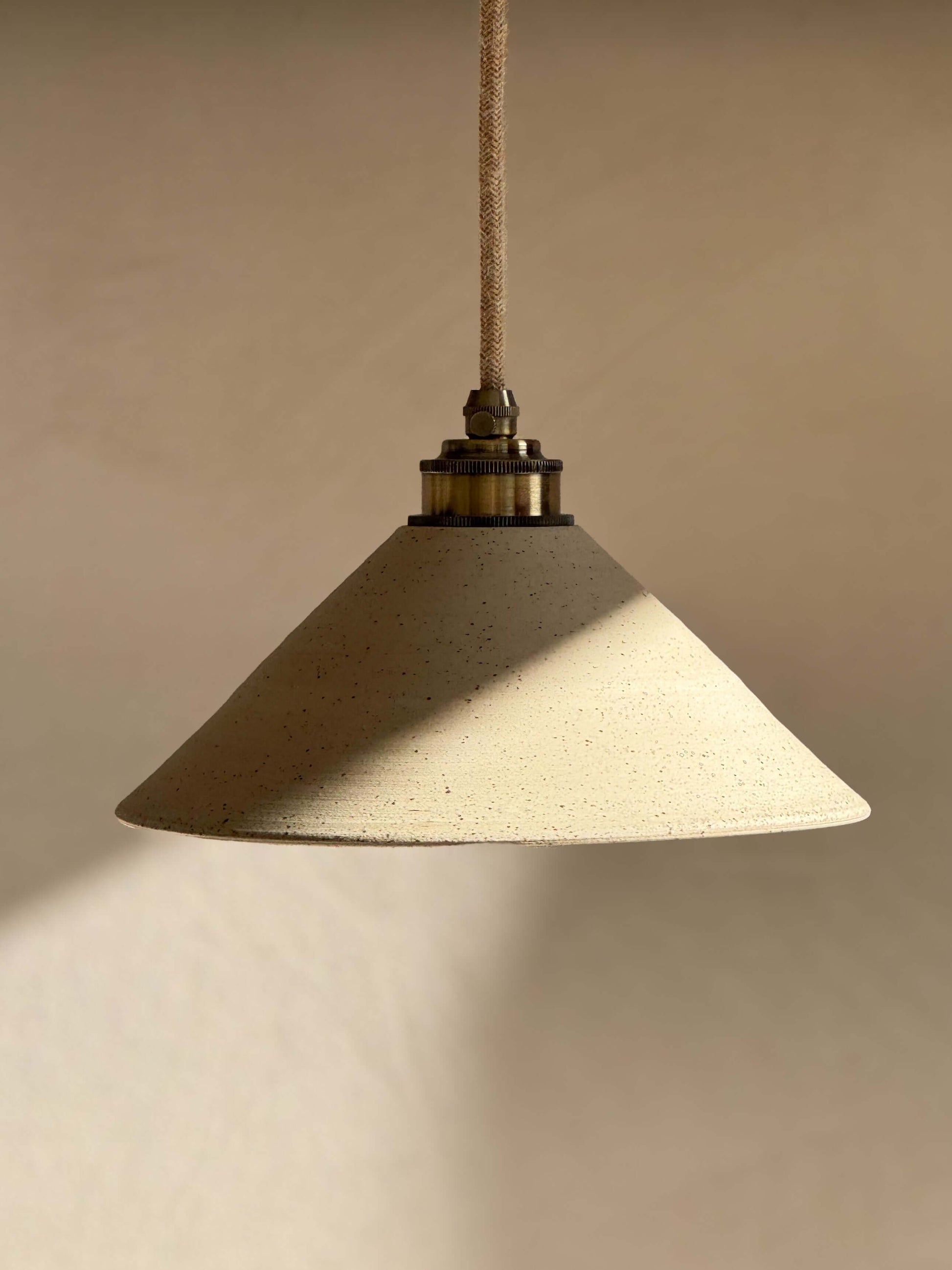Handmade Ceramic Lamp Shade – Half Clear Glaze #01 with unglazed exterior and clear glazed interior, hanging in warm light.