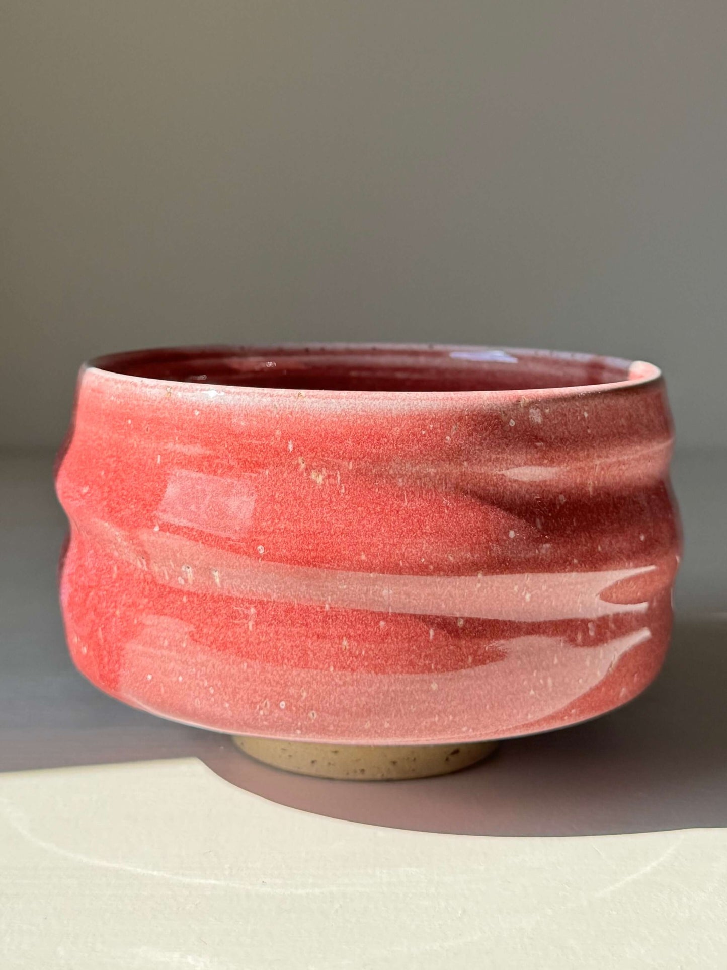 Handmade ceramic Matcha Bowl - Ume Series #01 with Ume blossom-inspired design, sculptural shape, and pink glaze on trimmed foot.