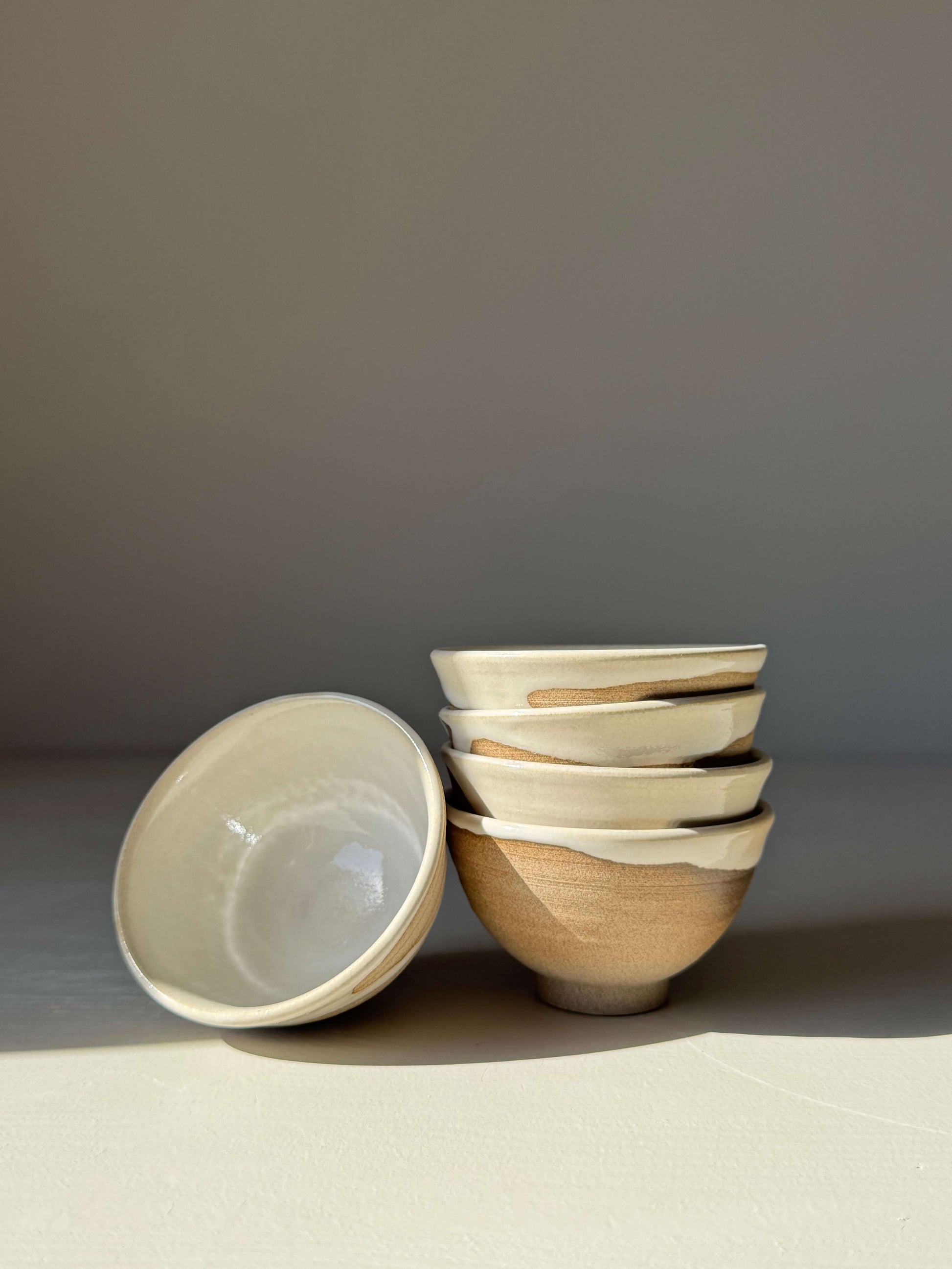 Soya Bowl - Yuki Series handmade ceramic bowls with soft white glaze and raw base, stacked and displayed on a surface.