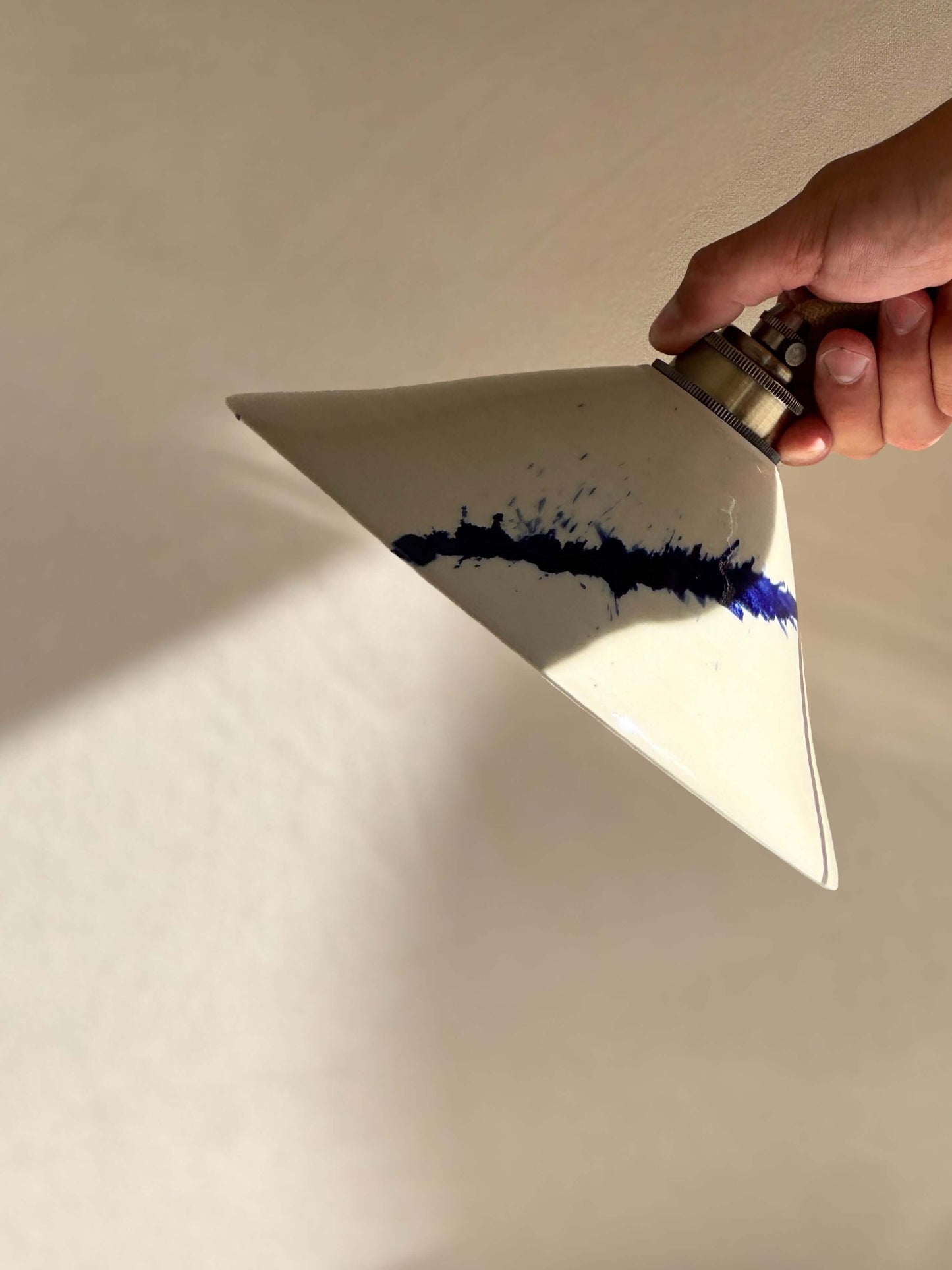 Hand holding Ceramic Lamp Shade – Gosu Series #02, handmade ceramic with cobalt blue accents, showcasing the unique design.