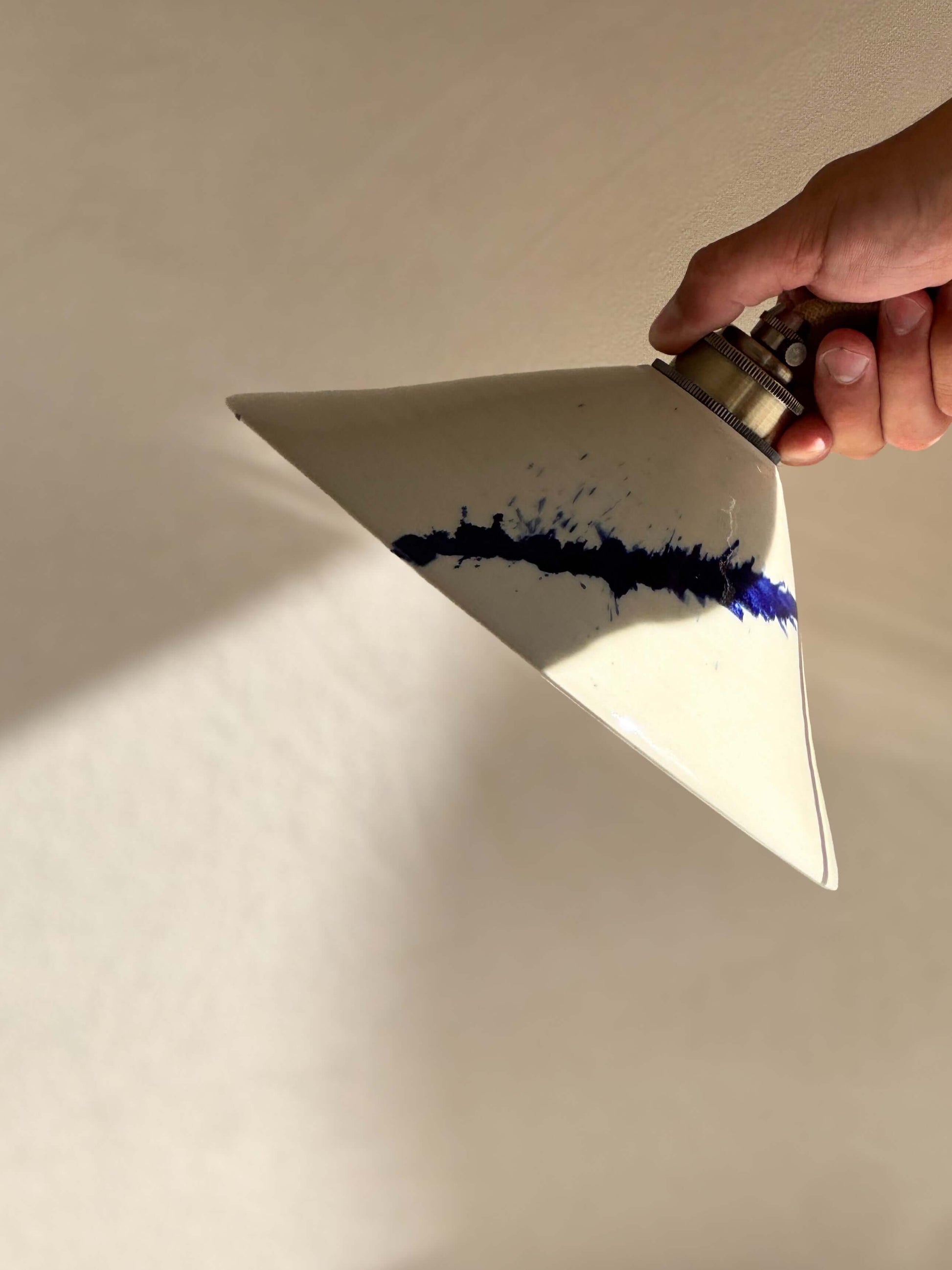 Hand holding Ceramic Lamp Shade – Gosu Series #02, handmade ceramic with cobalt blue accents, showcasing the unique design.