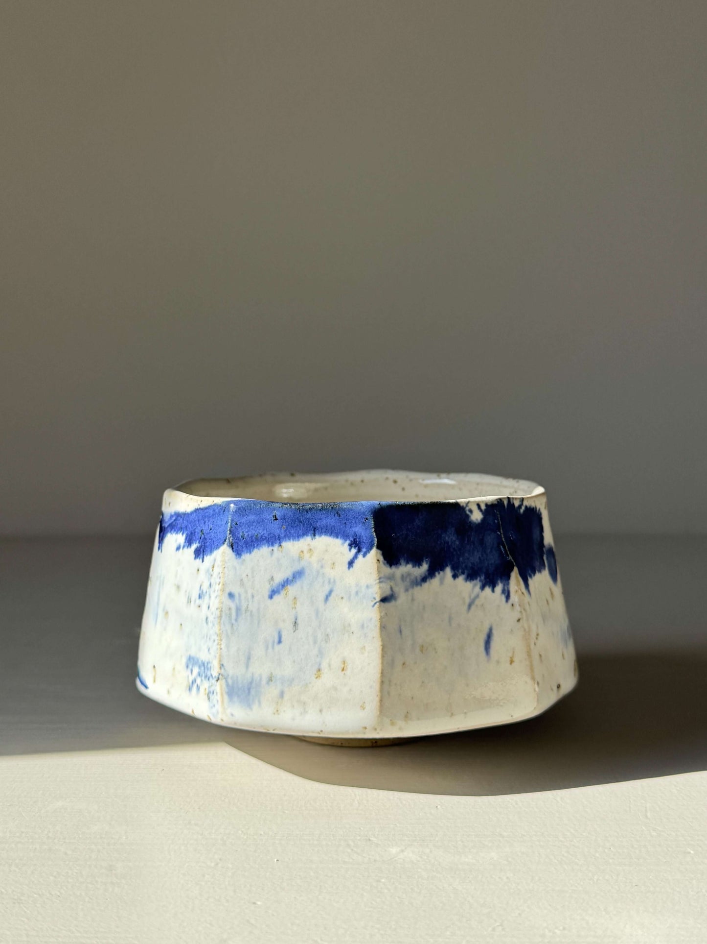 Handmade ceramic Faceted Matcha Bowl – Cobalt Blue & Glossy White Glaze #05 with textured facets and cobalt blue splashes.