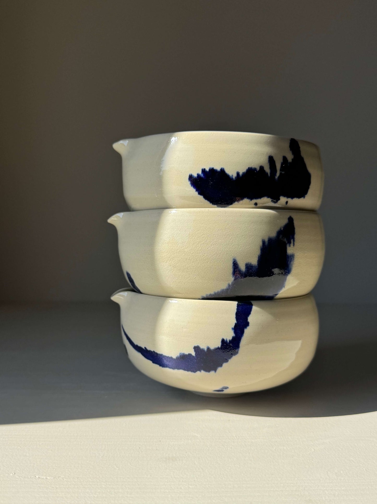 Stacked handmade ceramic Katakuchi Matcha Bowl with Spout – Gosu Series featuring bold cobalt splashes.