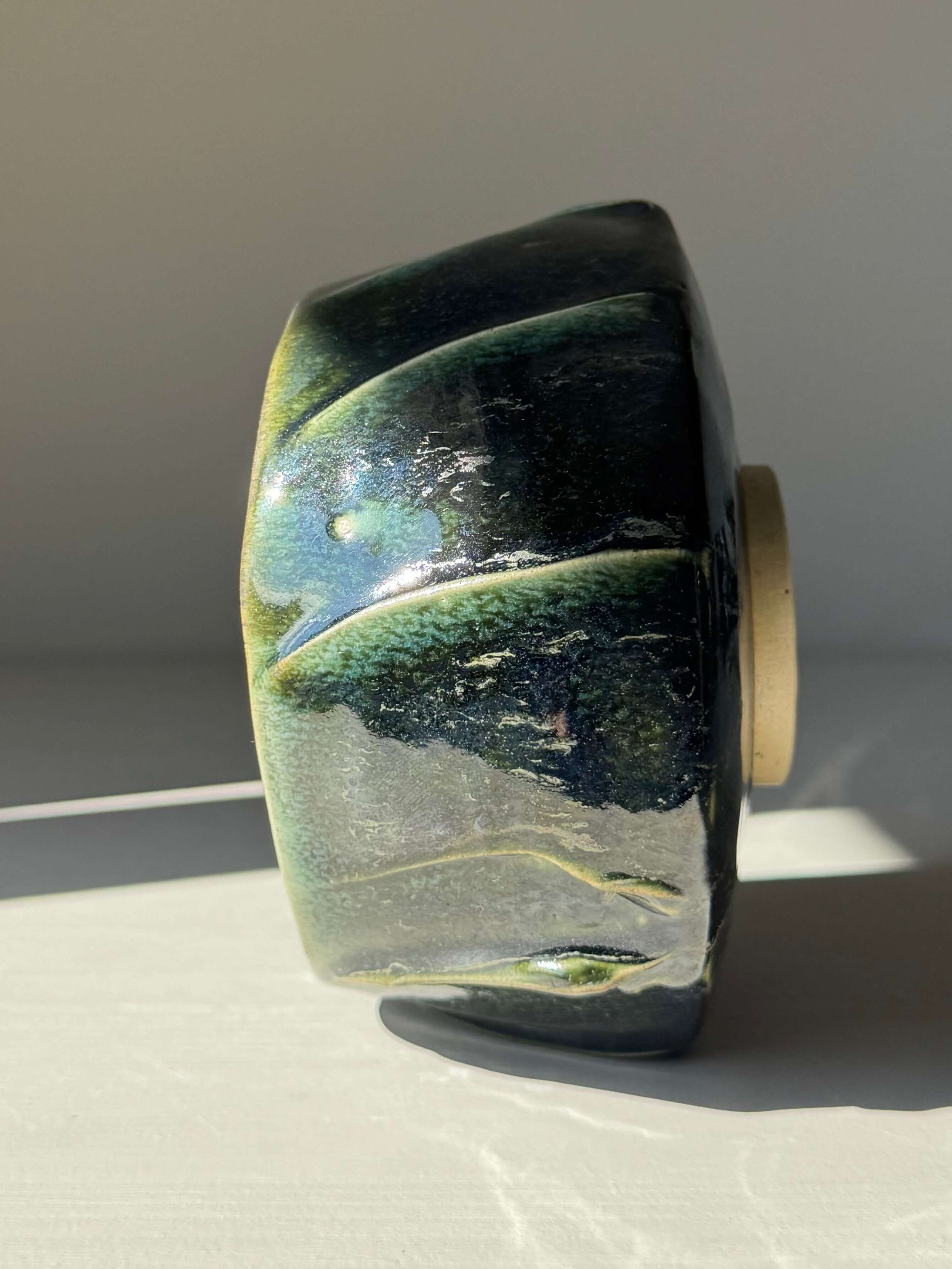 Side view of the handmade ceramic Textured Matcha Bowl - Hinoki Series #03, showcasing its unique green glaze and textured finish.