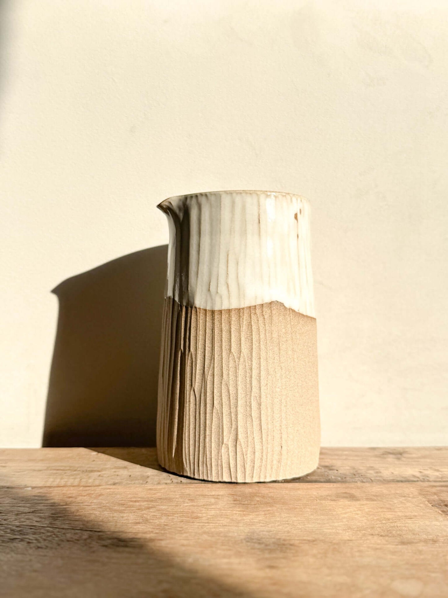 Medium vase jug from Yuki Series with hand-carved lines and glossy white glaze on top, showcasing natural texture and subtle elegance.