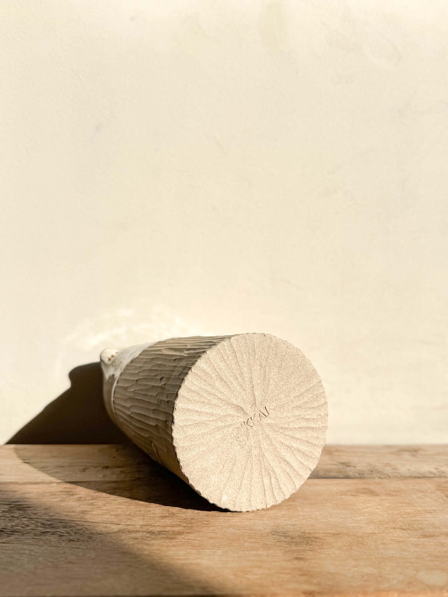 Bottom view of the Yuki Series 02 medium vase showing intricate hand-carved vertical lines with a natural, textured finish.