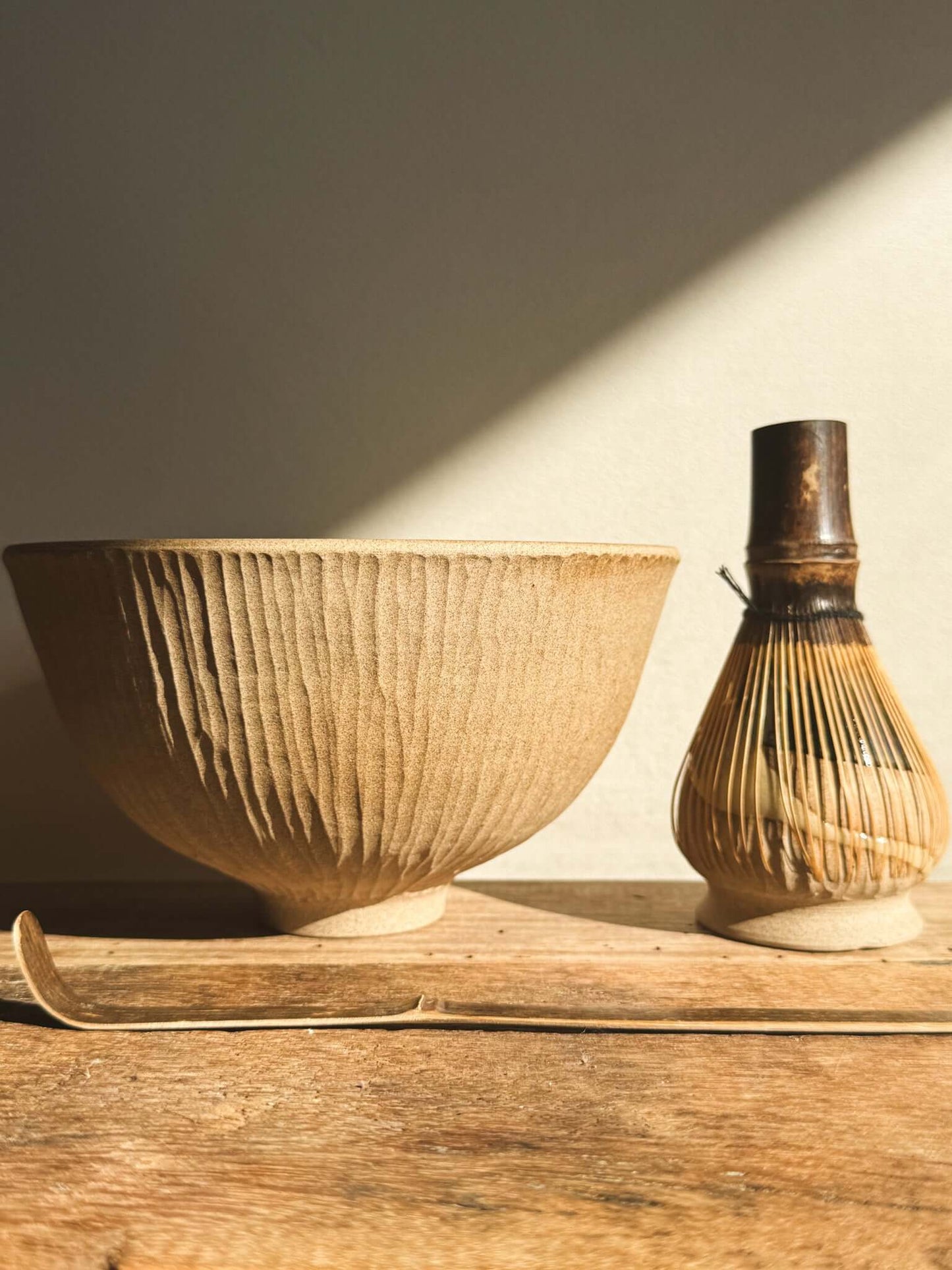 Matcha bowl and whisk holder set from Inyo Series, showcasing raw clay and glossy glaze balancing texture and flow.