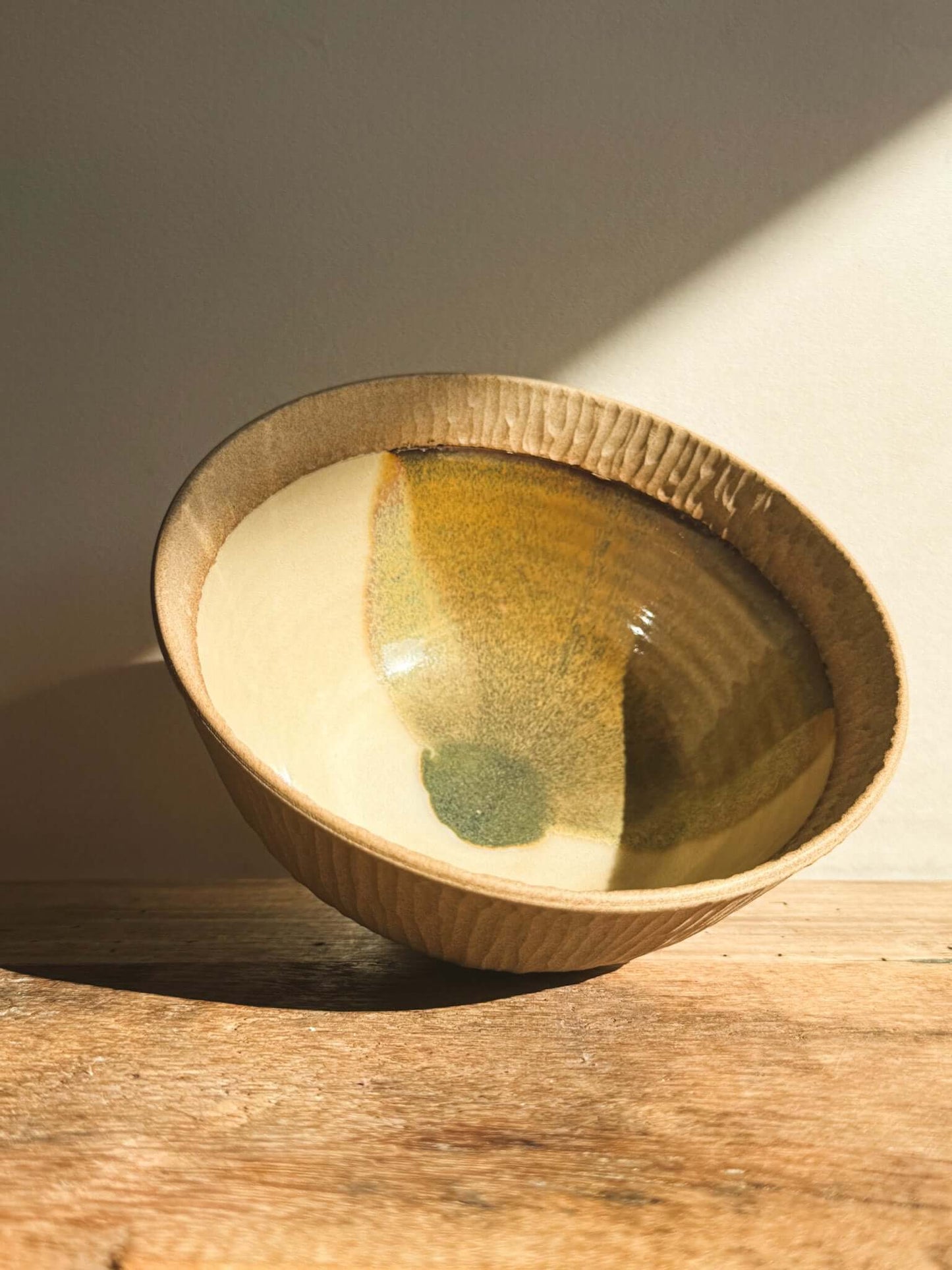 Golden-green glazed matcha bowl from Inyo Series, showcasing raw clay and glossy finish, emphasizing texture and balance.