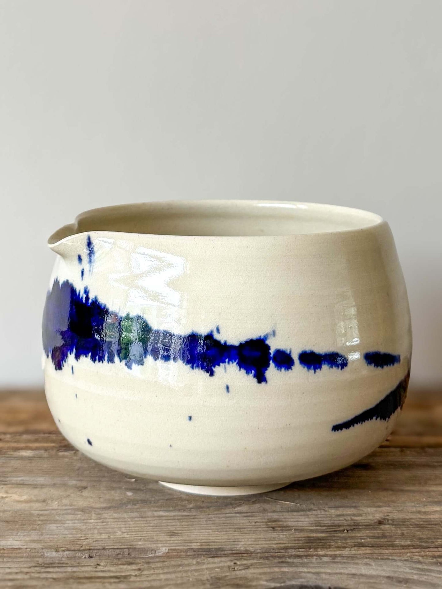 Katakuchi Matcha Bowl with Spout from Gosu Series, featuring dynamic cobalt blue glaze patterns on a white ceramic surface.