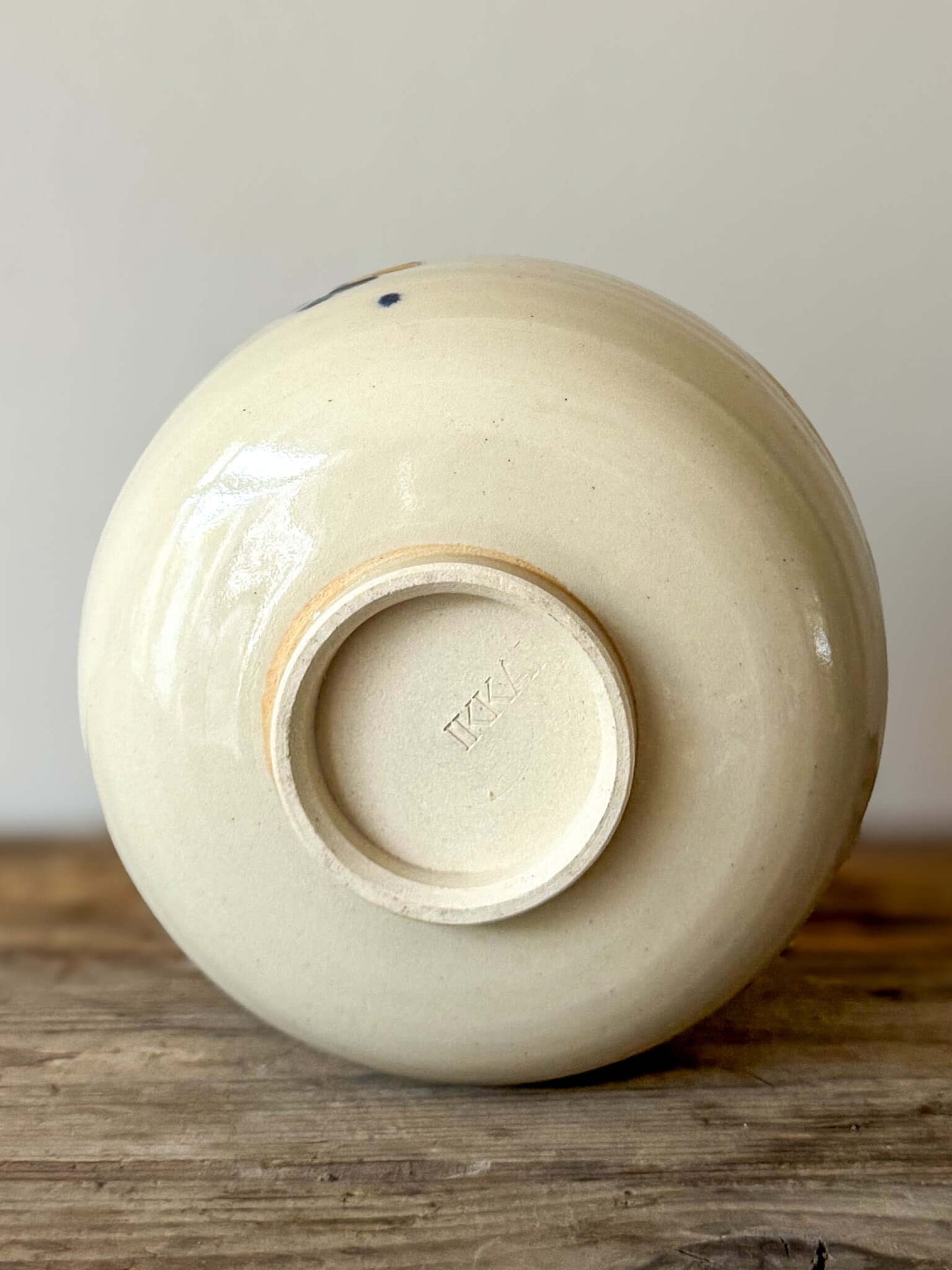 Underside view of the Rounded Matcha Bowl from the Gosu Series, featuring an off-white glaze and artist's hallmark.