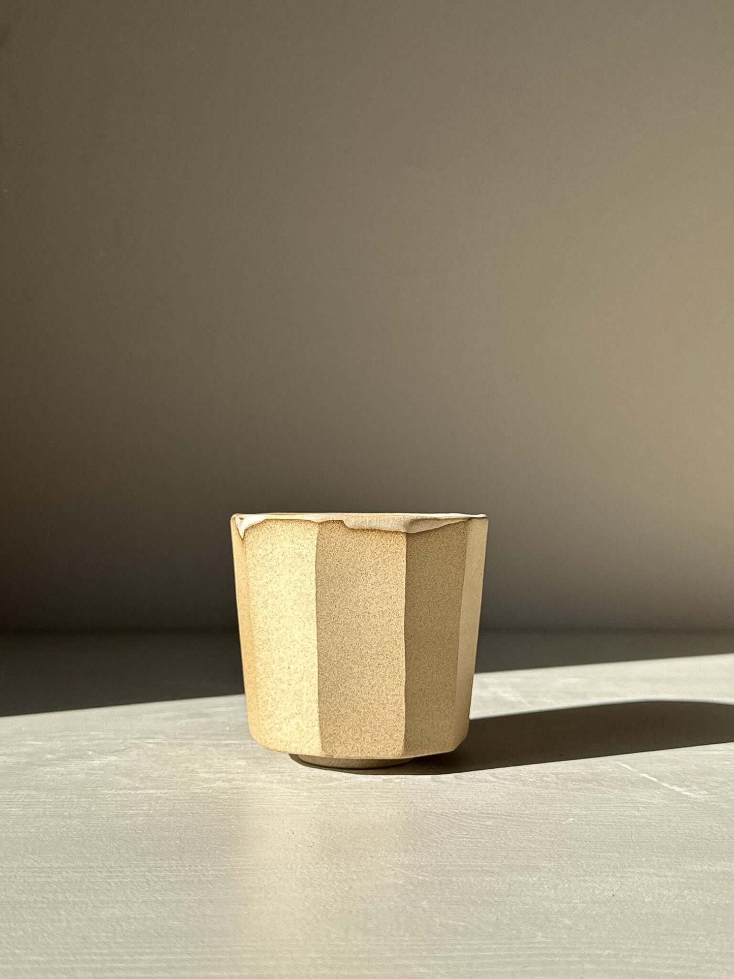 Faceted yunomi cup - Crackle Glaze with natural clay exterior in sunlight