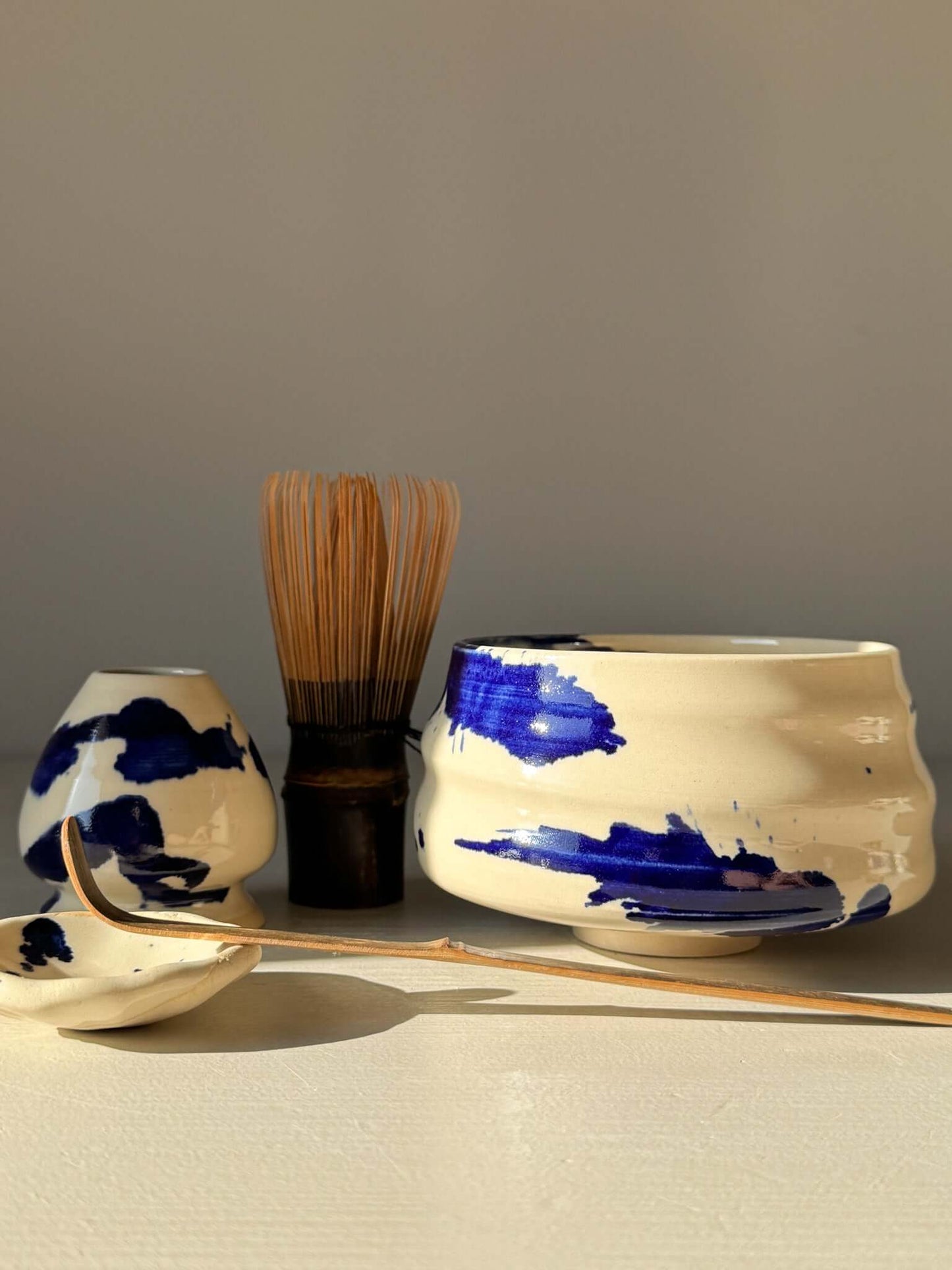 Matcha Bowl – Gosu Series #04 with cobalt glaze, tea whisk, and accessories in soft sunlight.
