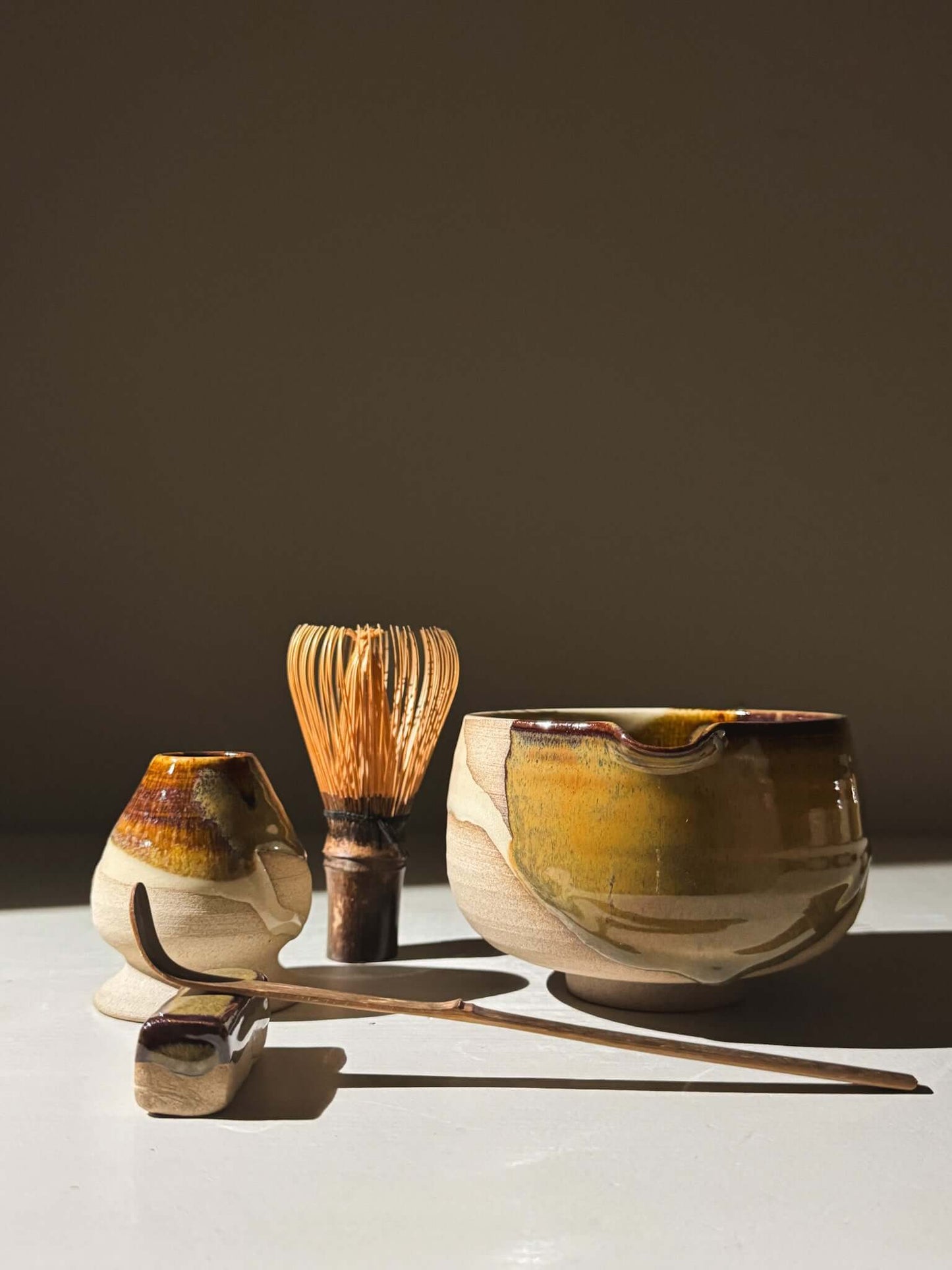 Matcha Bowl with Spout – Inyo #06 featuring handmade clay design with dark tenmoku and clear glazes, displayed with whisk and scoop.