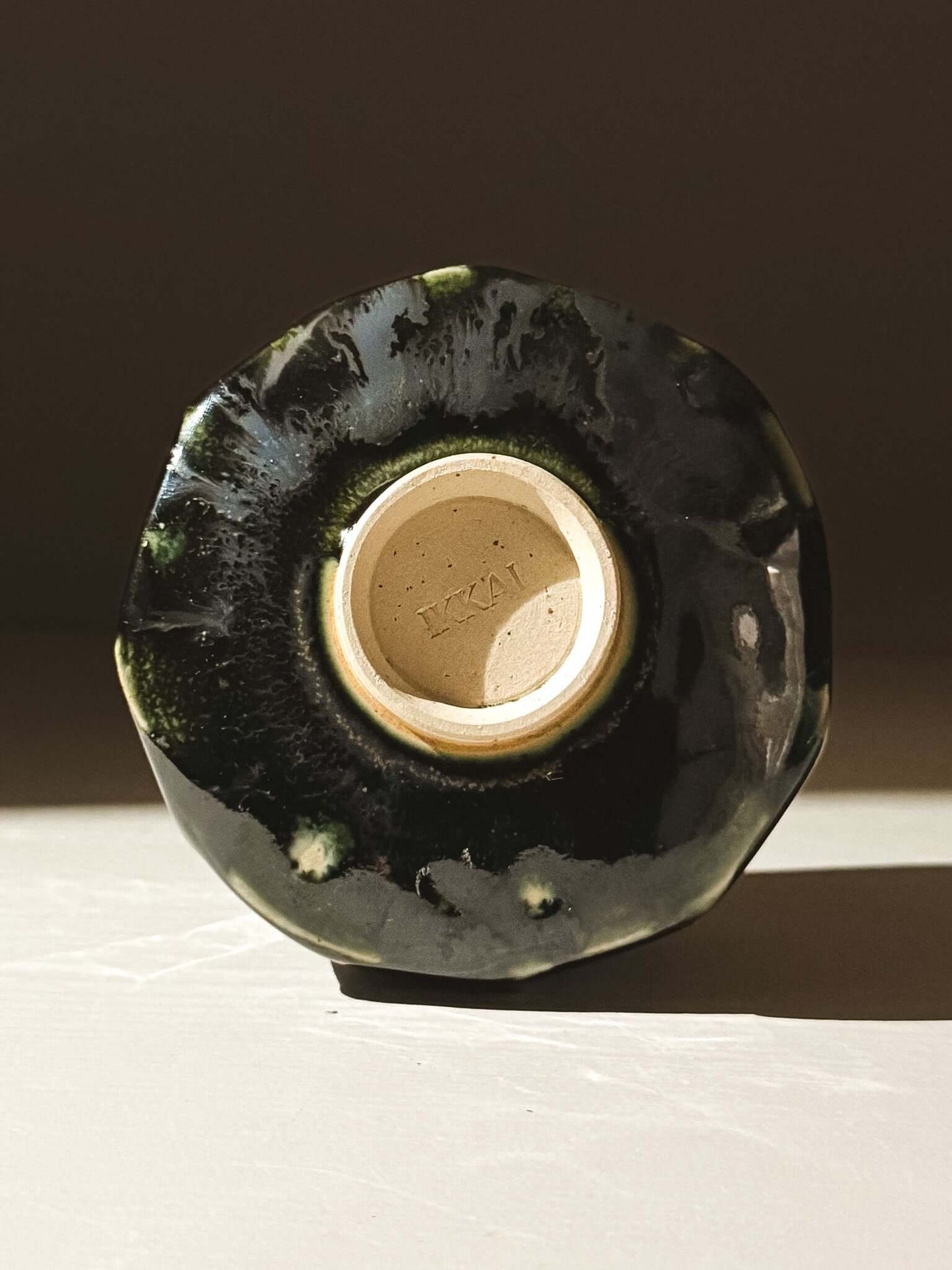 Bottom view of handcrafted Yunomi Cup - Hinoki #02 with deep green glaze and unique textured design.