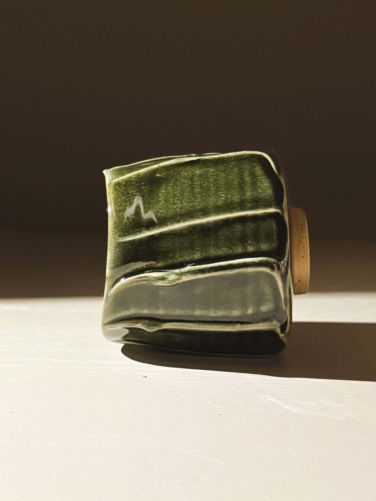 Yunomi Cup - Hinoki #06 with handmade deep green glaze and textured slip decoration on display.
