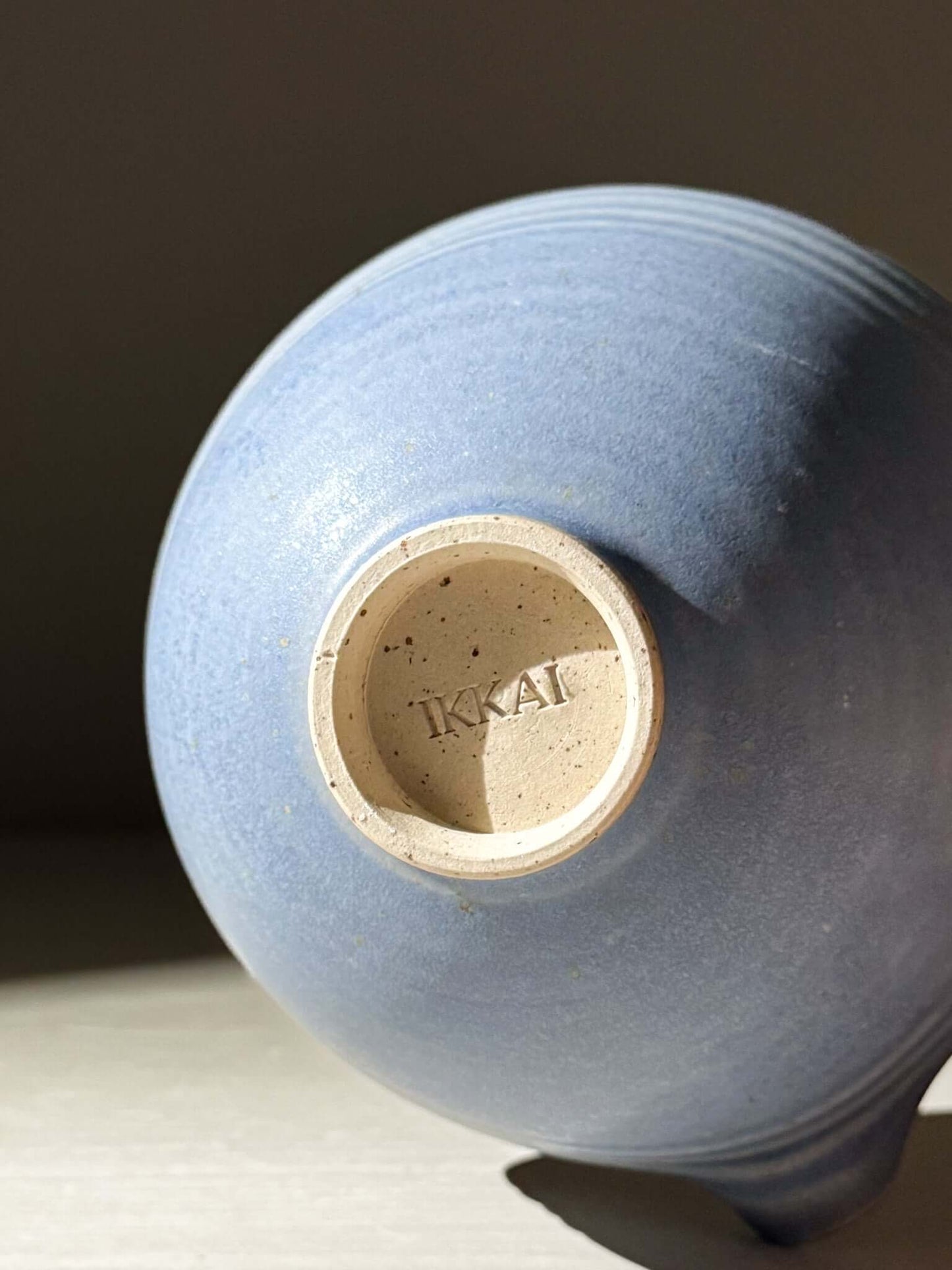 Underside view of Matcha Bowl & Whisk Holder Set - Blue #04 with soft blue glaze finish showcasing craftsmanship and IKAI brand mark.