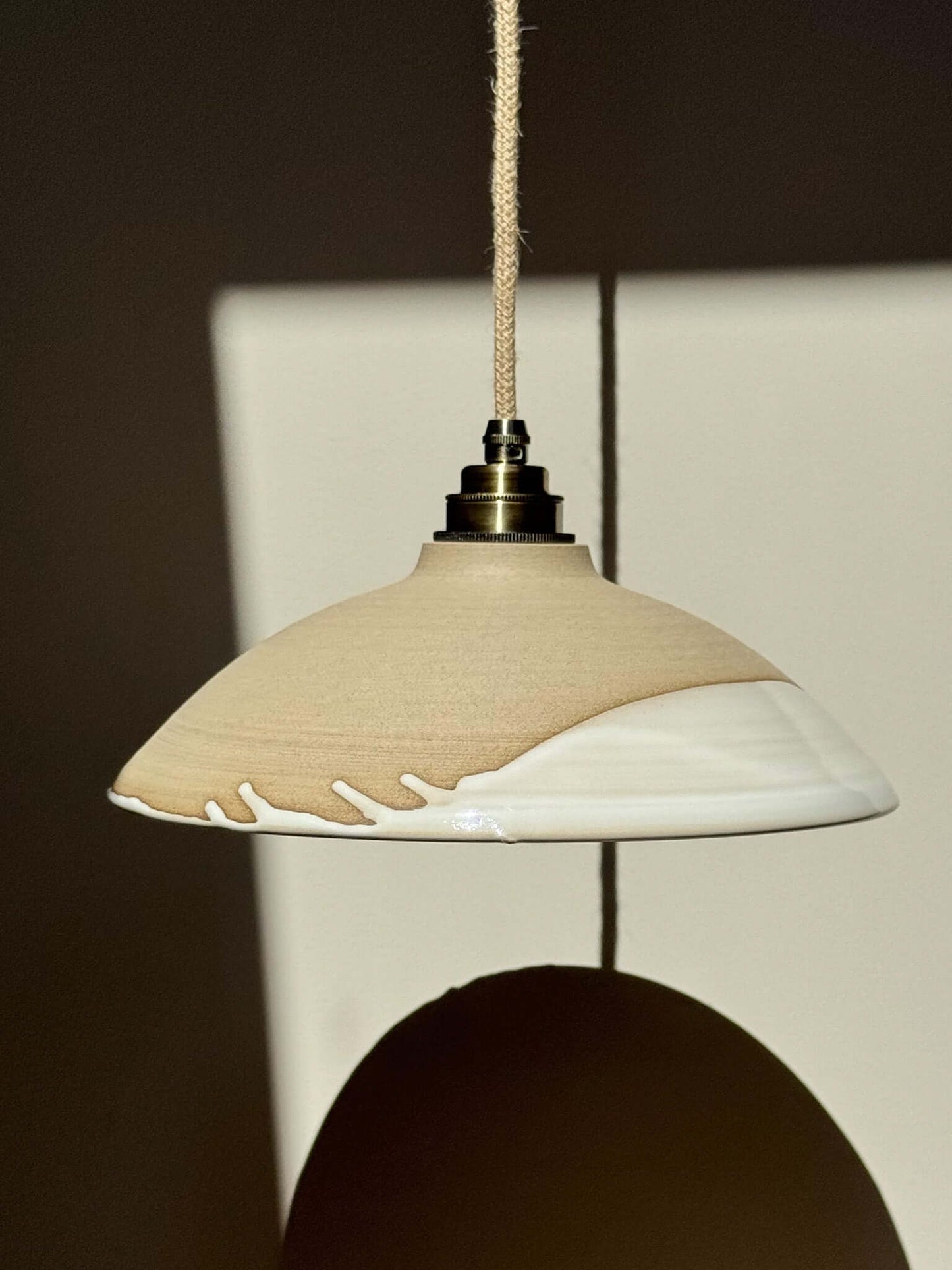 Ceramic Lamp Shade – Yuki #01 with raw exterior and glossy white interior, highlighting a creamy glaze line, adding elegance to any space.
