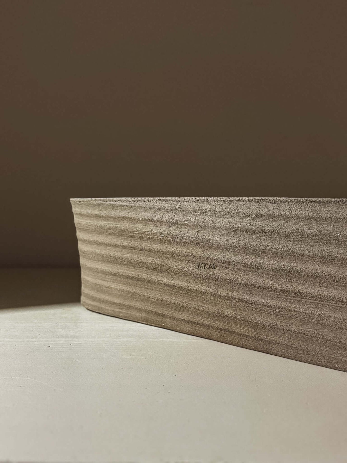 Side view of the Sushi Plate – Yuki Ash #01 showcasing its minimalist, ash-grey design with gentle curves.