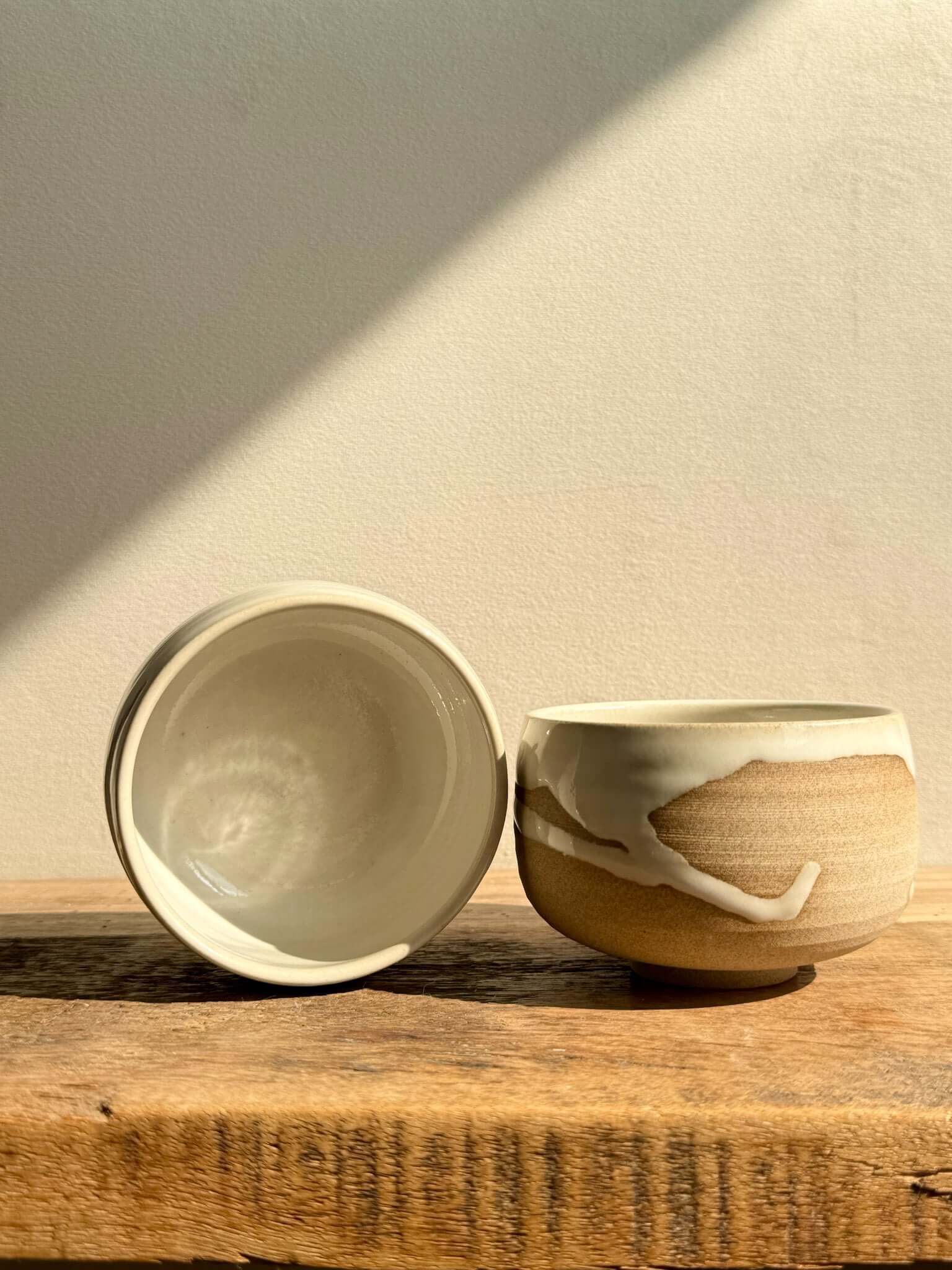 Handmade ceramic Coffee cups - Yuki Series with toffee clay and white glaze on a wooden surface.