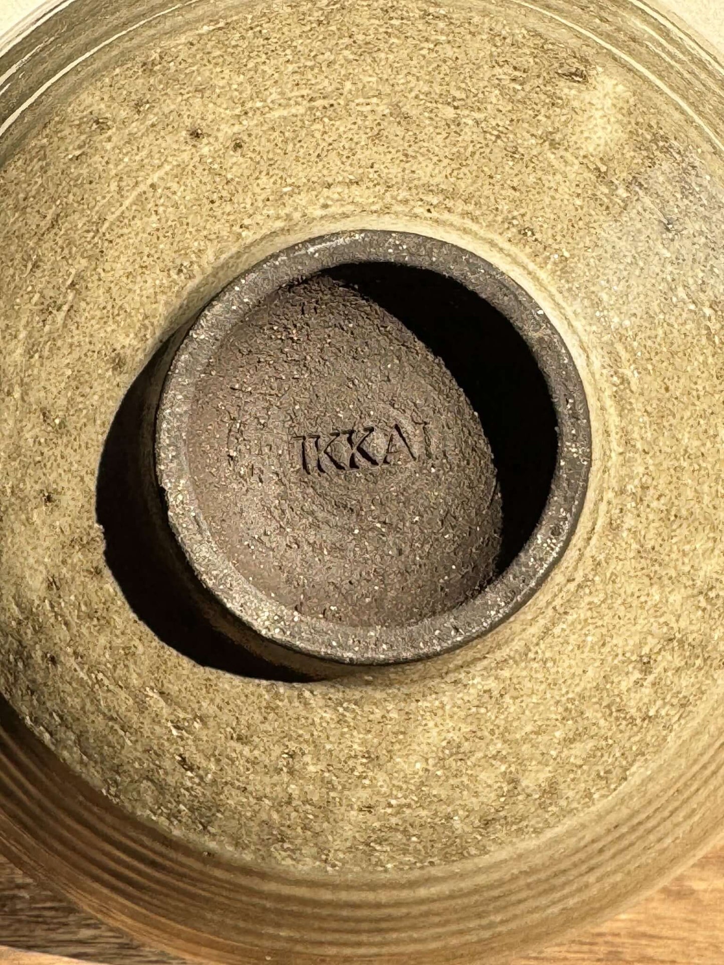 Alt Tag: Inner base of Yuki Series Dark Clay bowl showcasing textured stoneware and maker's mark in a natural light.