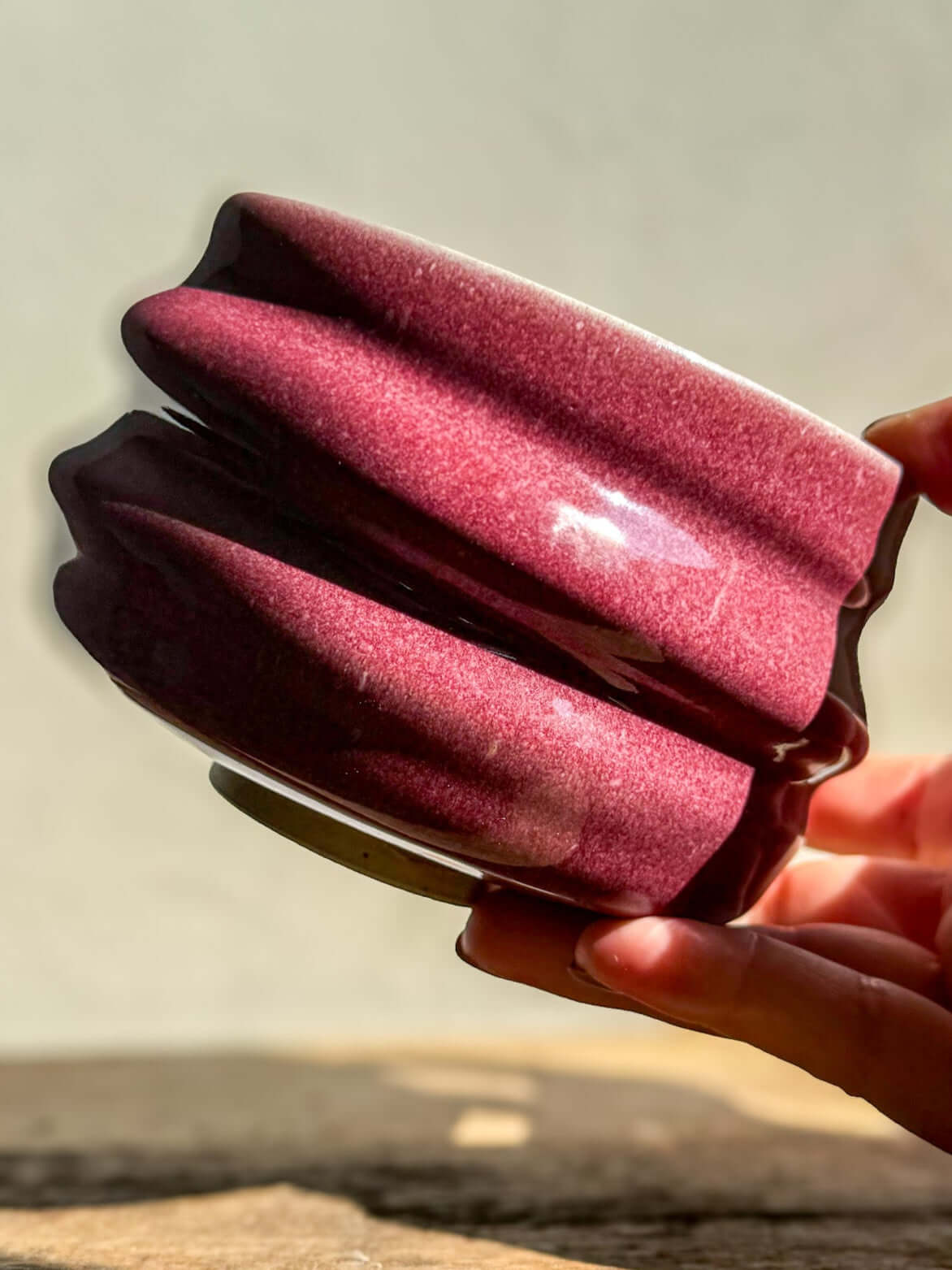 Person holding Ume Series #04 Matcha Bowl in vibrant pink, inspired by Japanese Ume blossom, showing rounded shape with flowing ridges.
