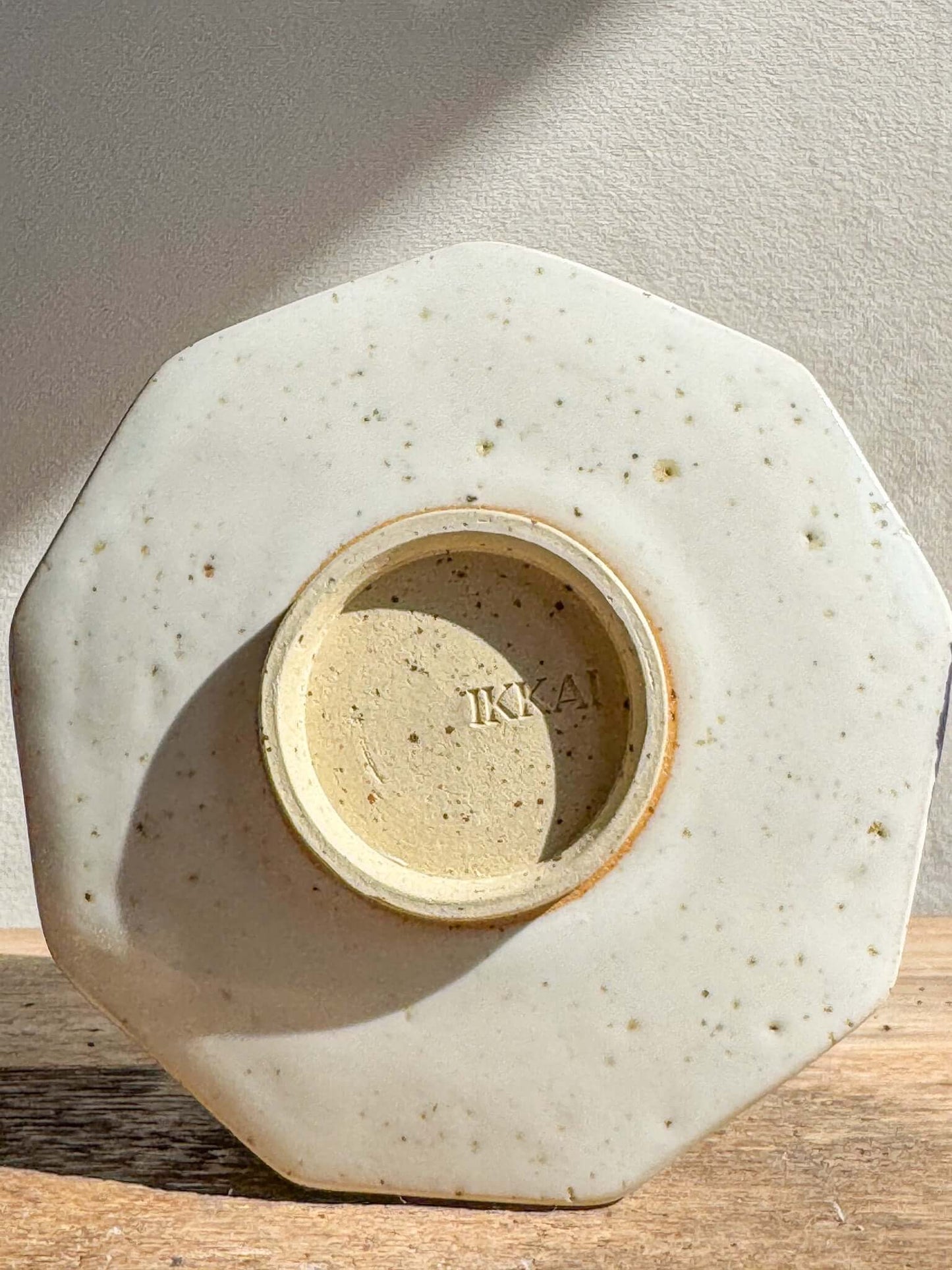 Underside view of faceted matcha bowl with glossy white glaze and stamped base. Ideal for modern kitchen decor.