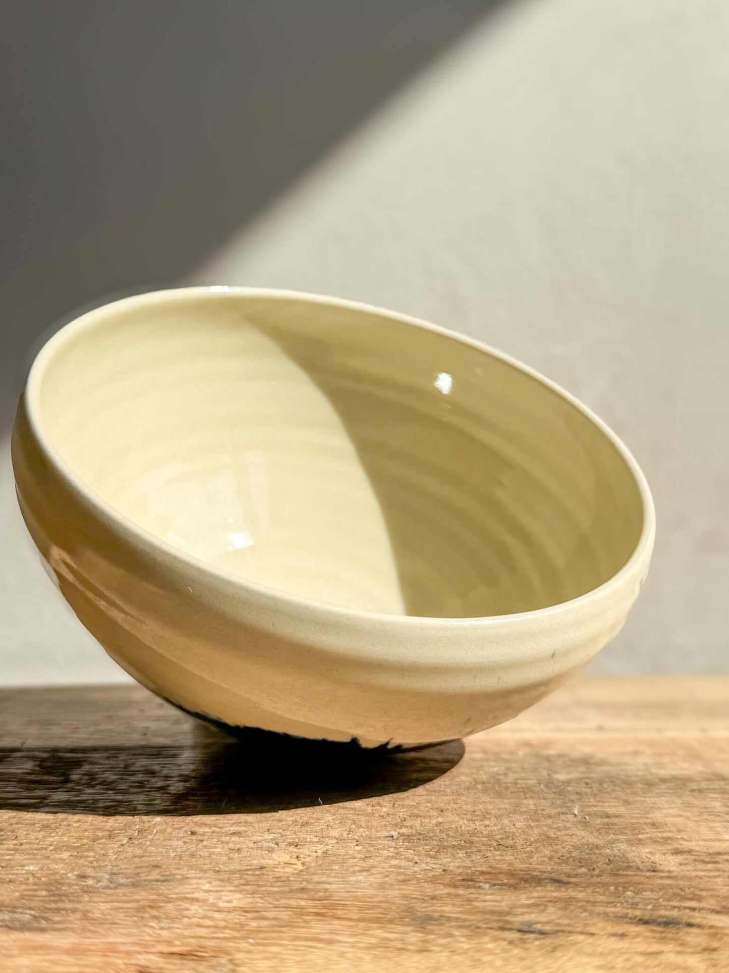 Rounded ceramic bowl with a soft glaze and sunlight reflection, part of the Gosu Series, ideal for breakfast or small meals.