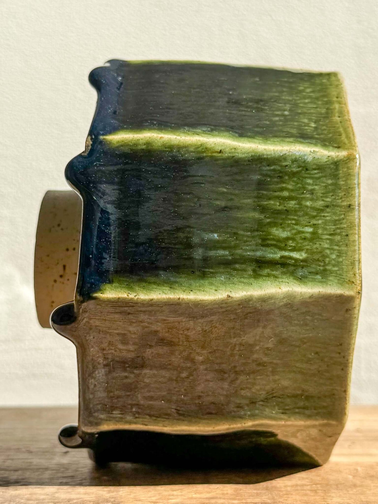 Side view of Faceted Matcha Bowl from Hinoki Series #03, showcasing hand-carved facets and deep green glaze drips.
