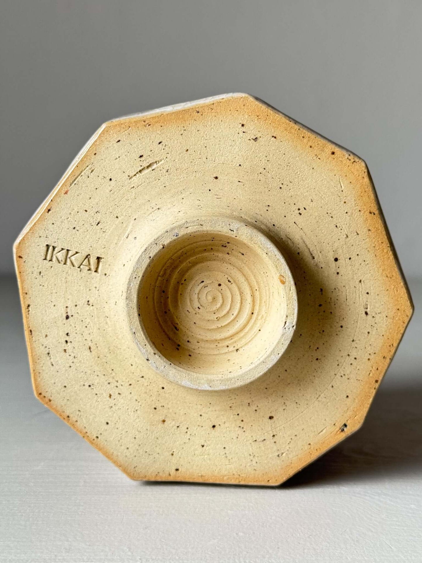 Bottom view of faceted matcha bowl with kannyū crackle glaze and geometric design, showcasing the textured base and Ikai branding.
