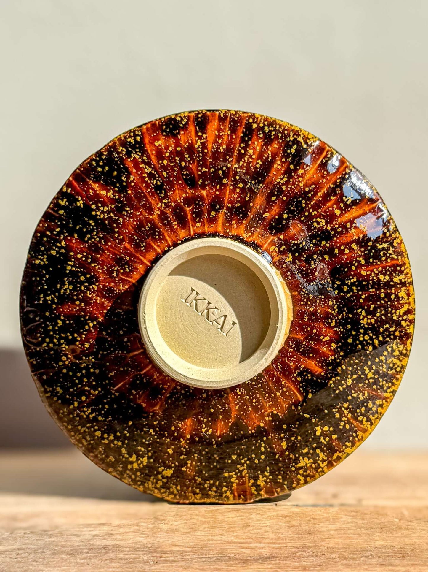 Kinsei #02 Matcha Bowl with galaxy-inspired gold and orange spiral, glossy brown exterior, and luminous starry design