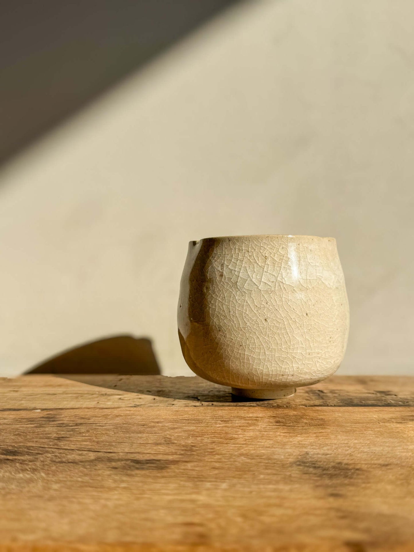 Yunomi Cup from Kannyū Series with crackle glaze, showcasing delicate patterns and a softly flowing rim on a wooden surface.