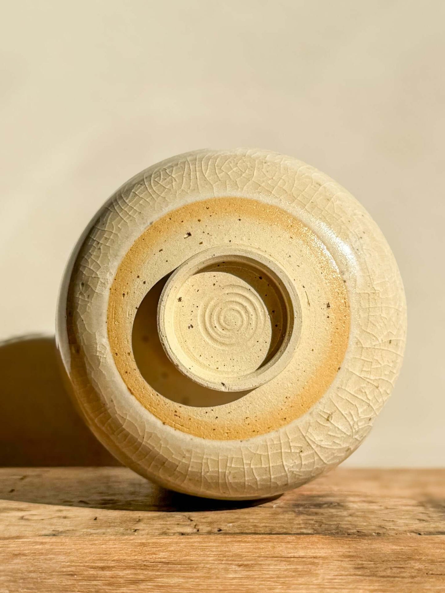 Base view of Yunomi Cup #02 from Kannyū Series, showcasing transparent crackle glaze and wheel-thrown spiral design.