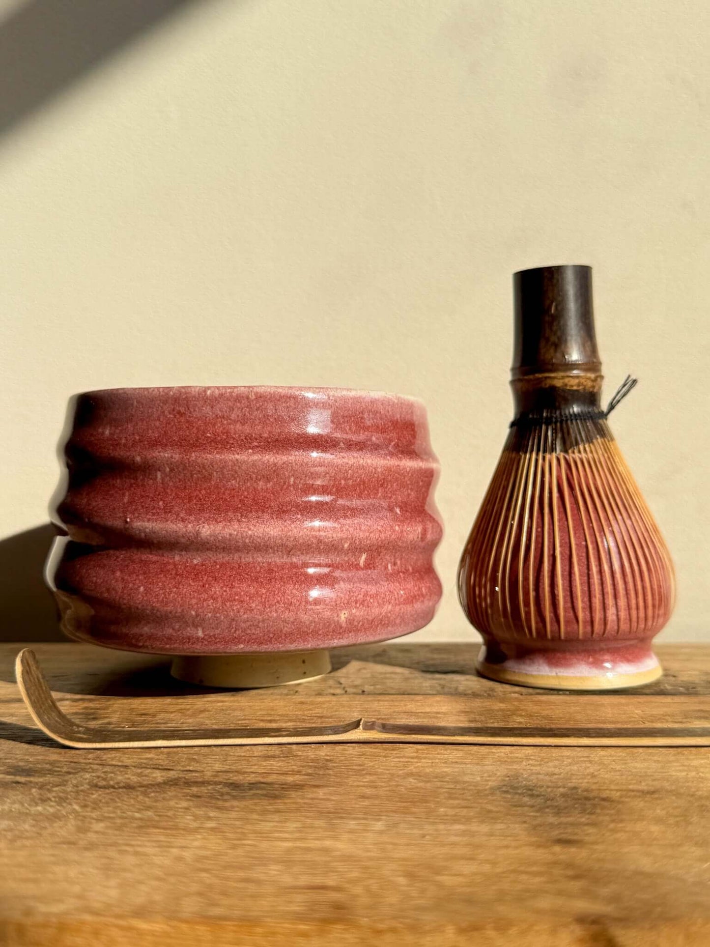 Ceramic Matcha Whisk Holder from Ume Series with bamboo Chasen whisk, inspired by Japanese plum blossom, enhancing tea preparation.