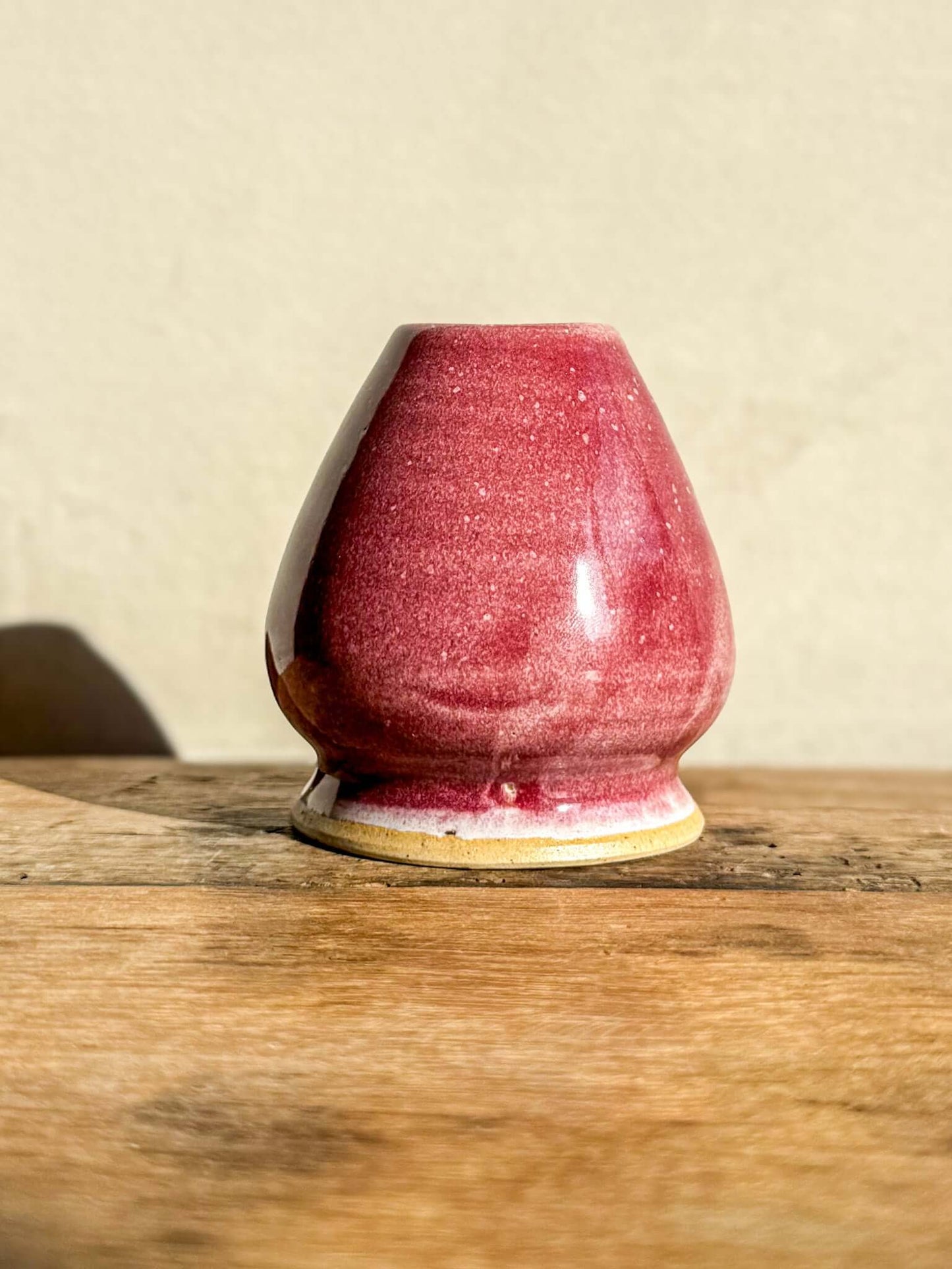 Red ceramic Matcha whisk holder from the Ume Series, designed to maintain bamboo Chasen shape and longevity, inspired by plum blossoms.