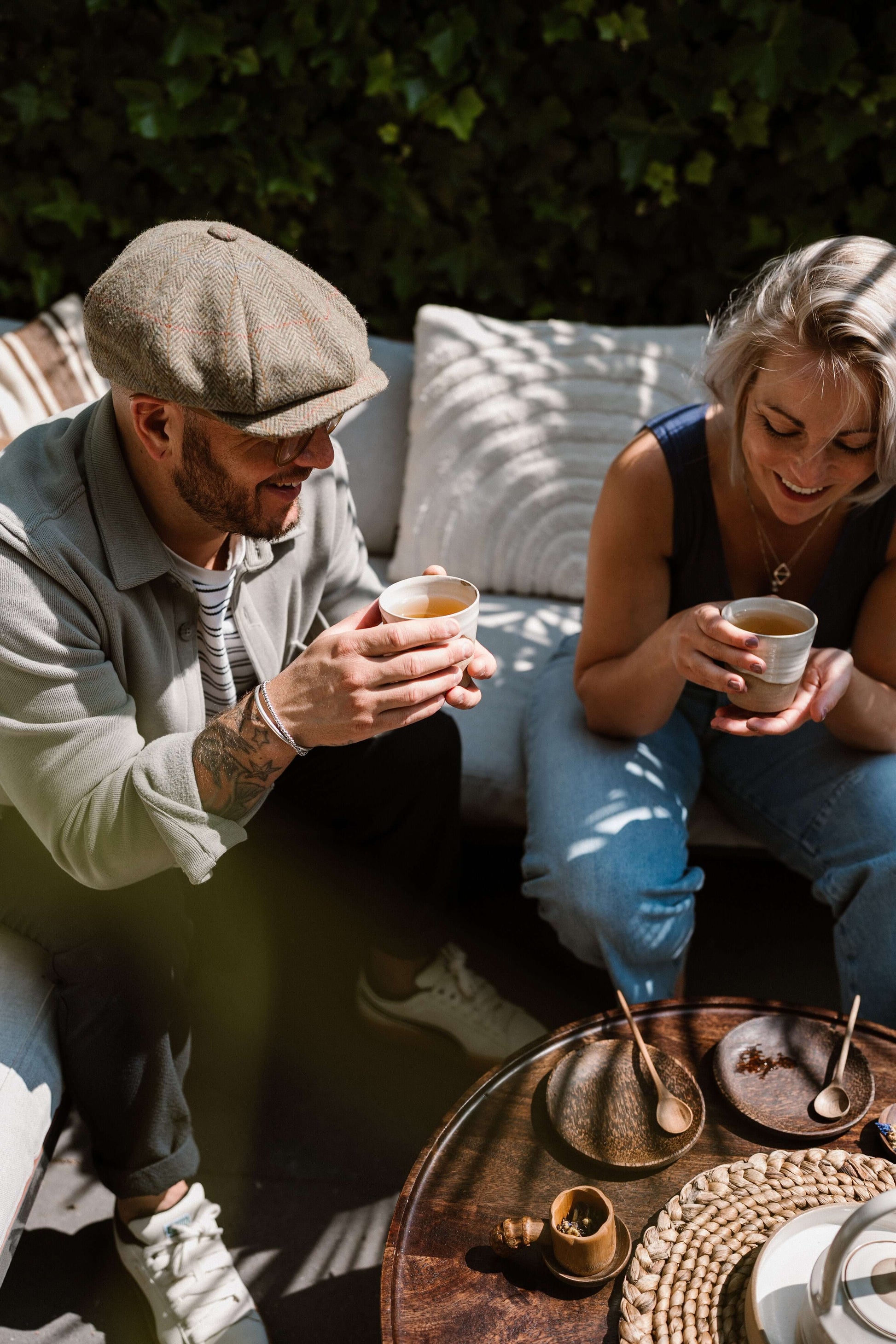Friends enjoying coffee outdoors with Coconut Wood Side Plates and handmade ceramic cups.