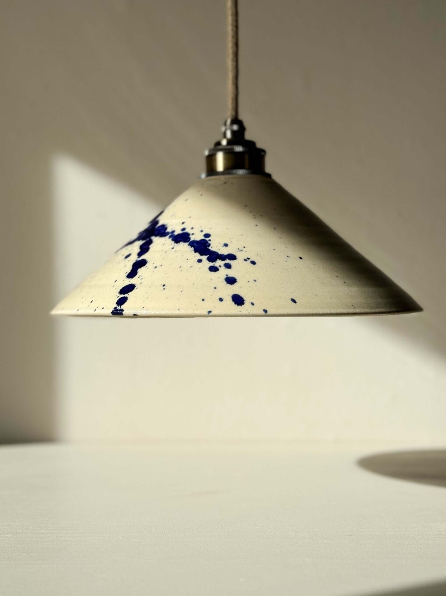 Handmade ceramic lamp shade from Gosu Series with hand-splashed cobalt blue accents, showcasing unique design and glossy finish.