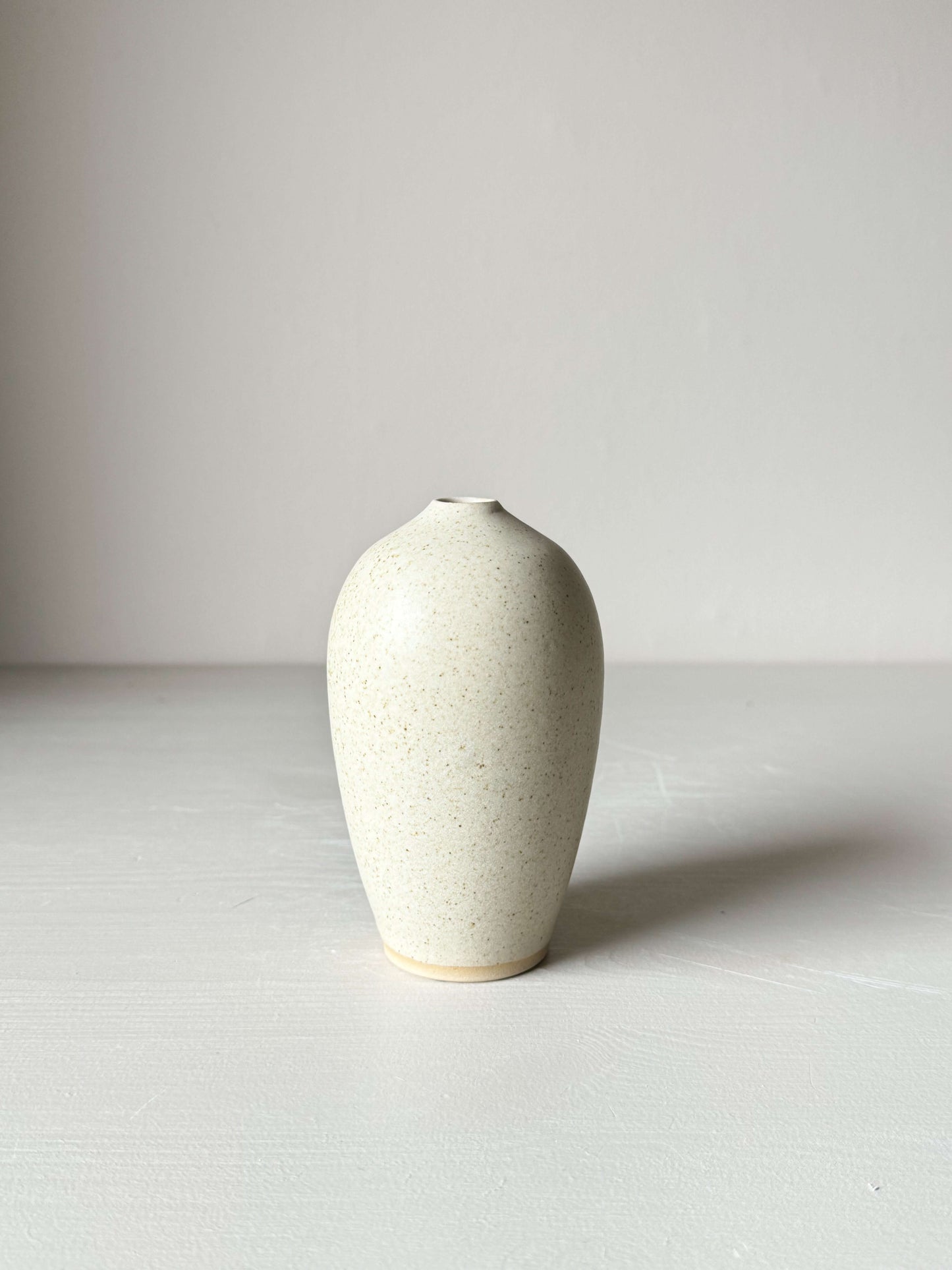 Ceramic vase with speckled matte cream glaze and narrow opening, perfect for single stem or ikebana, 13 cm tall, elegant design.
