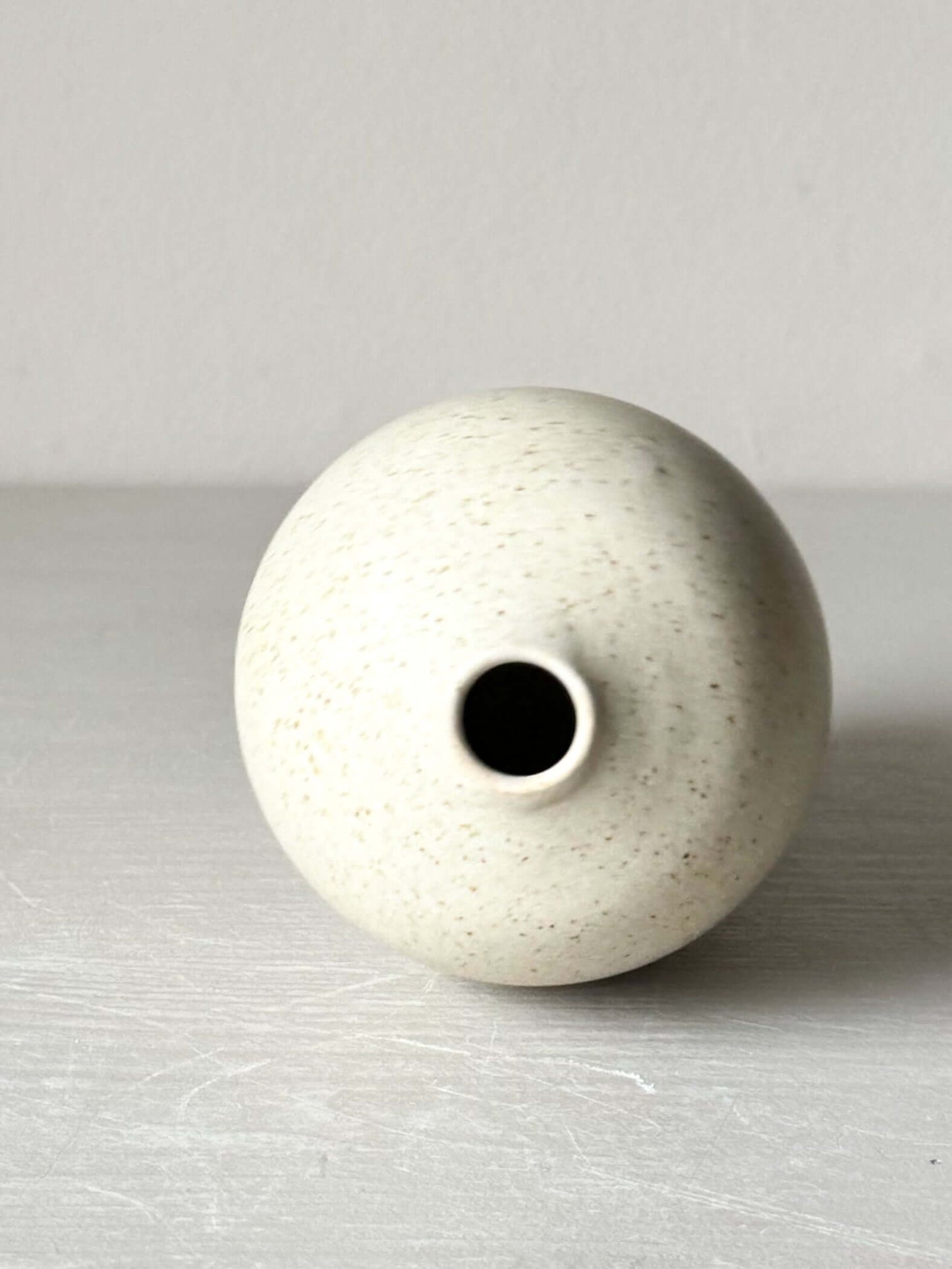 Ceramic vase with speckled matte cream glaze, perfect for single stem or ikebana arrangement, measuring 13 cm tall.