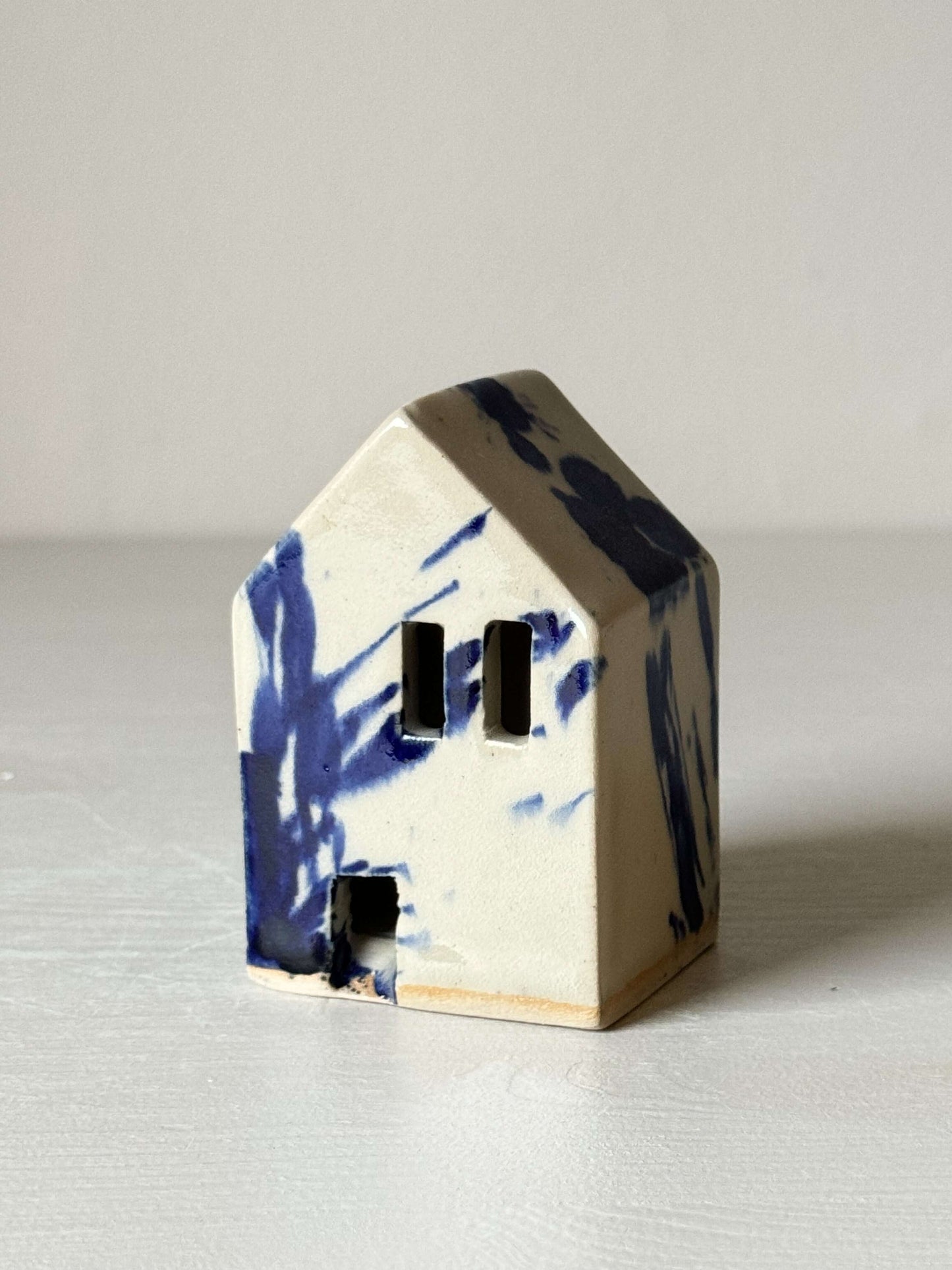 Handbuilt ceramic house with cobalt blue splashes, part of the Gosu Series, adding a quirky, Dutch-inspired charm to any room.