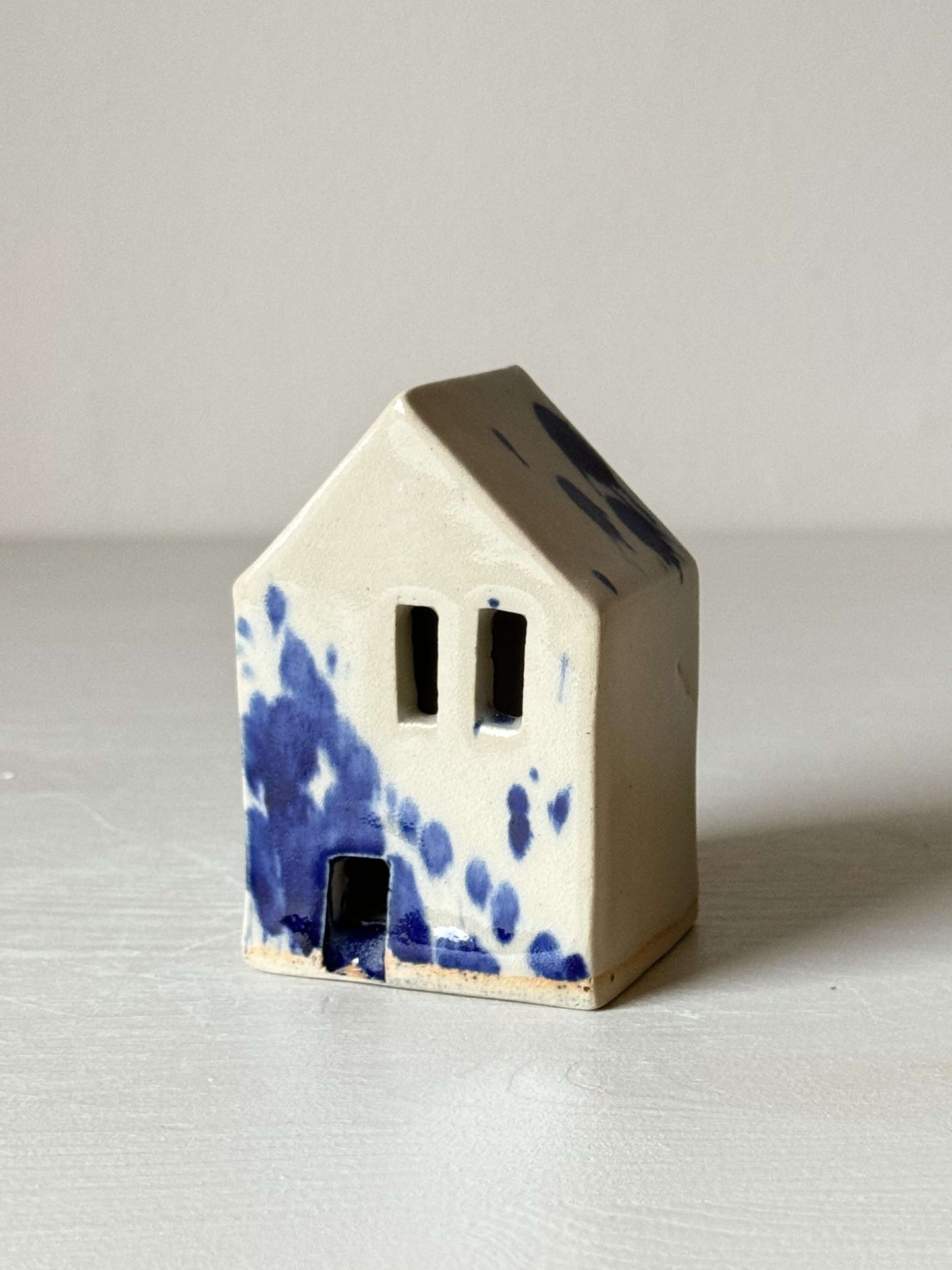 Handbuilt ceramic house with cobalt blue splashes, part of the Gosu Series. Perfect for home decor. Size: 8.5 cm x 5.5 cm x 4.5 cm.