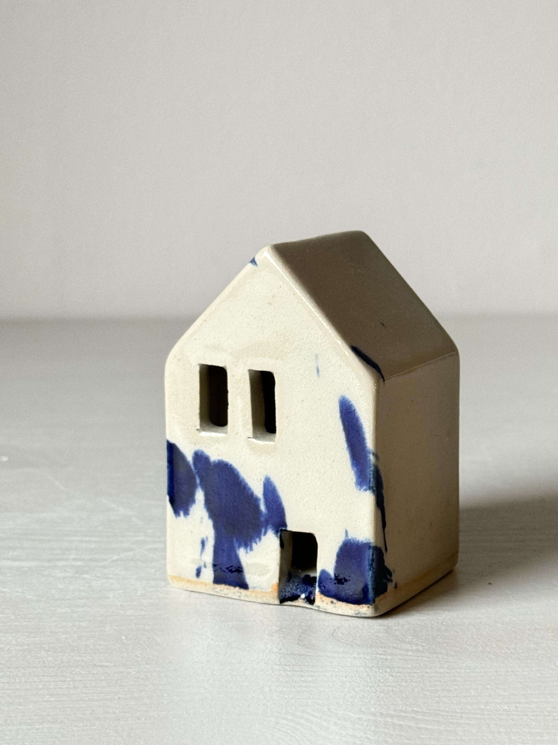 Handbuilt Ceramic Houses – Gosu Series handmade ceramic house with cobalt blue splashes on a white background.