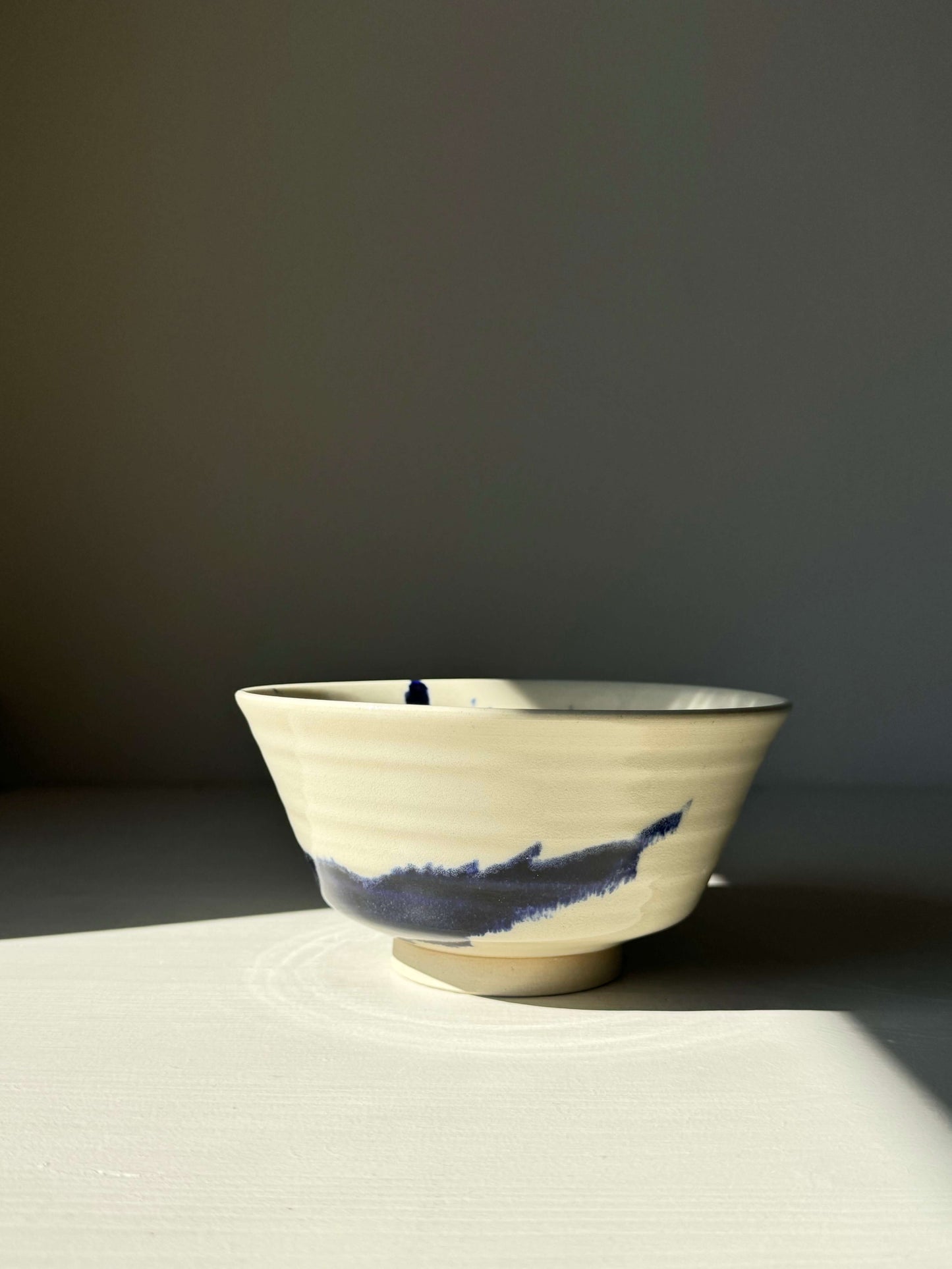 Handcrafted Gosu Series rice bowl with cobalt blue splashes under clear glaze, highlighting unique design and natural clay texture.