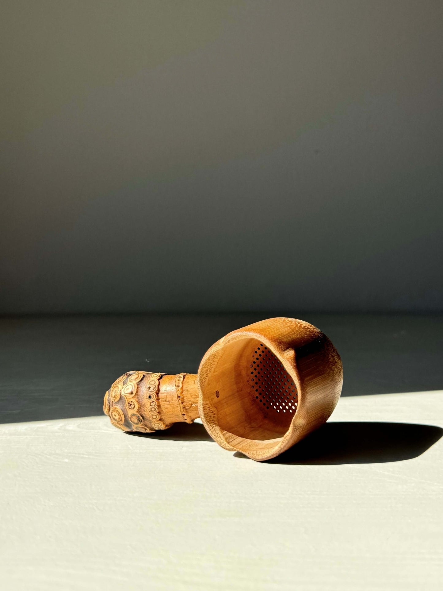 Handmade bamboo tea strainer with textured root handle, perfect for enhancing tea rituals with rustic charm and practicality.