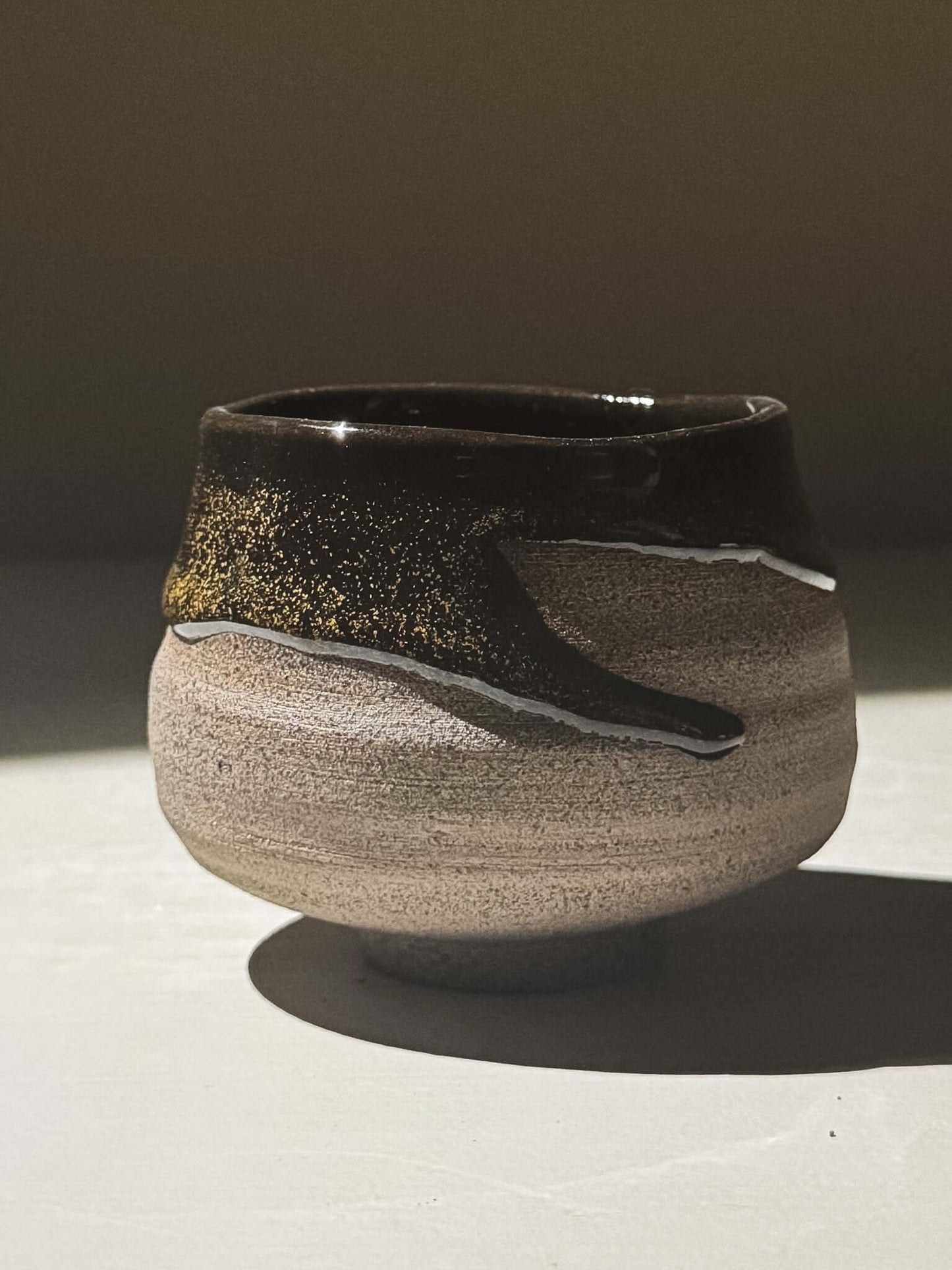 Yunomi Cup - Kuro Ash #02 with glossy black glaze and subtle golden speckles on a stoneware base.